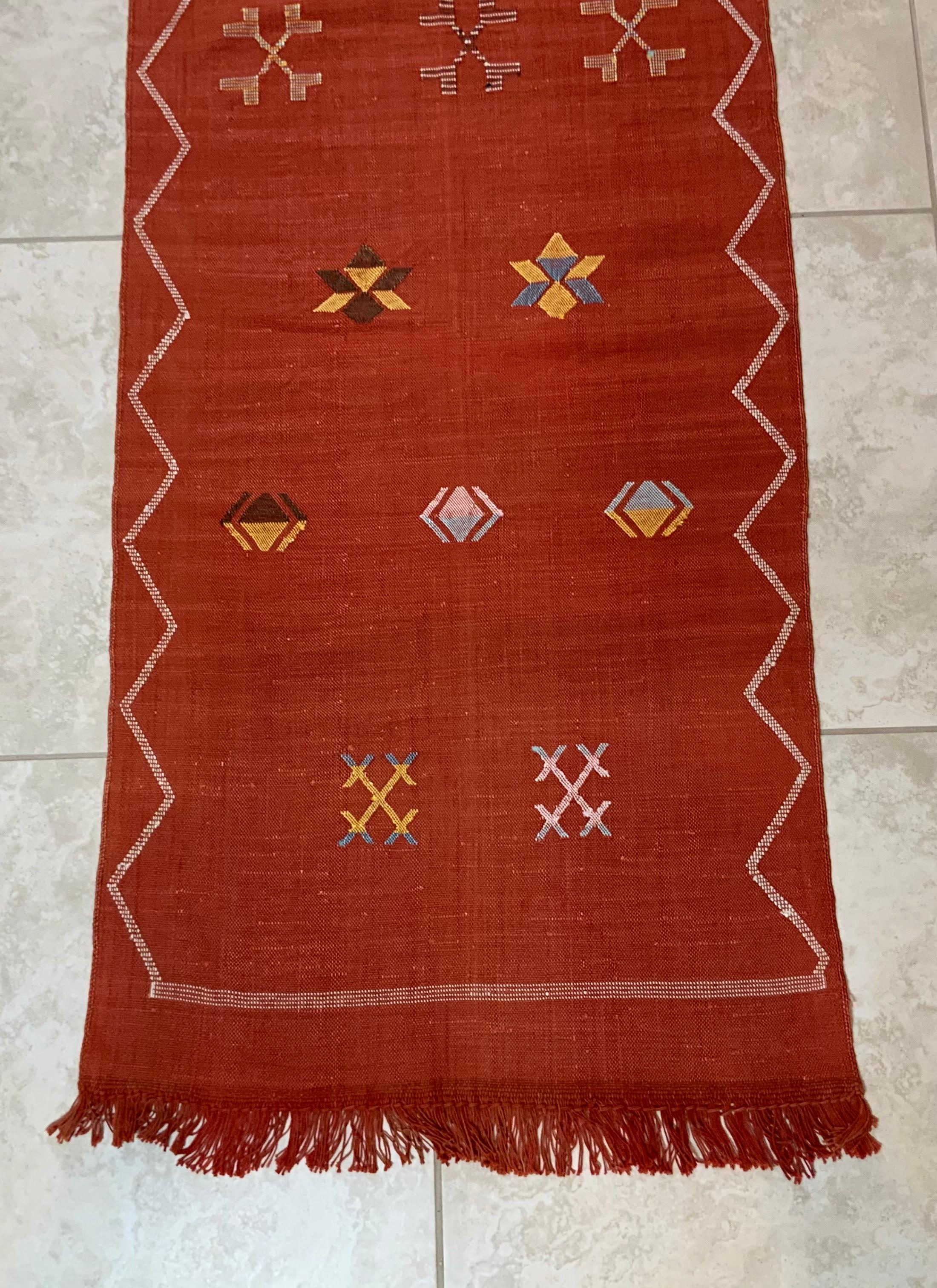 Beautiful handwoven rug runner made of cactus silk with soft multi-color geometric motifs on a red - color background, nicely feel to touch. Great decorative addition for any room.