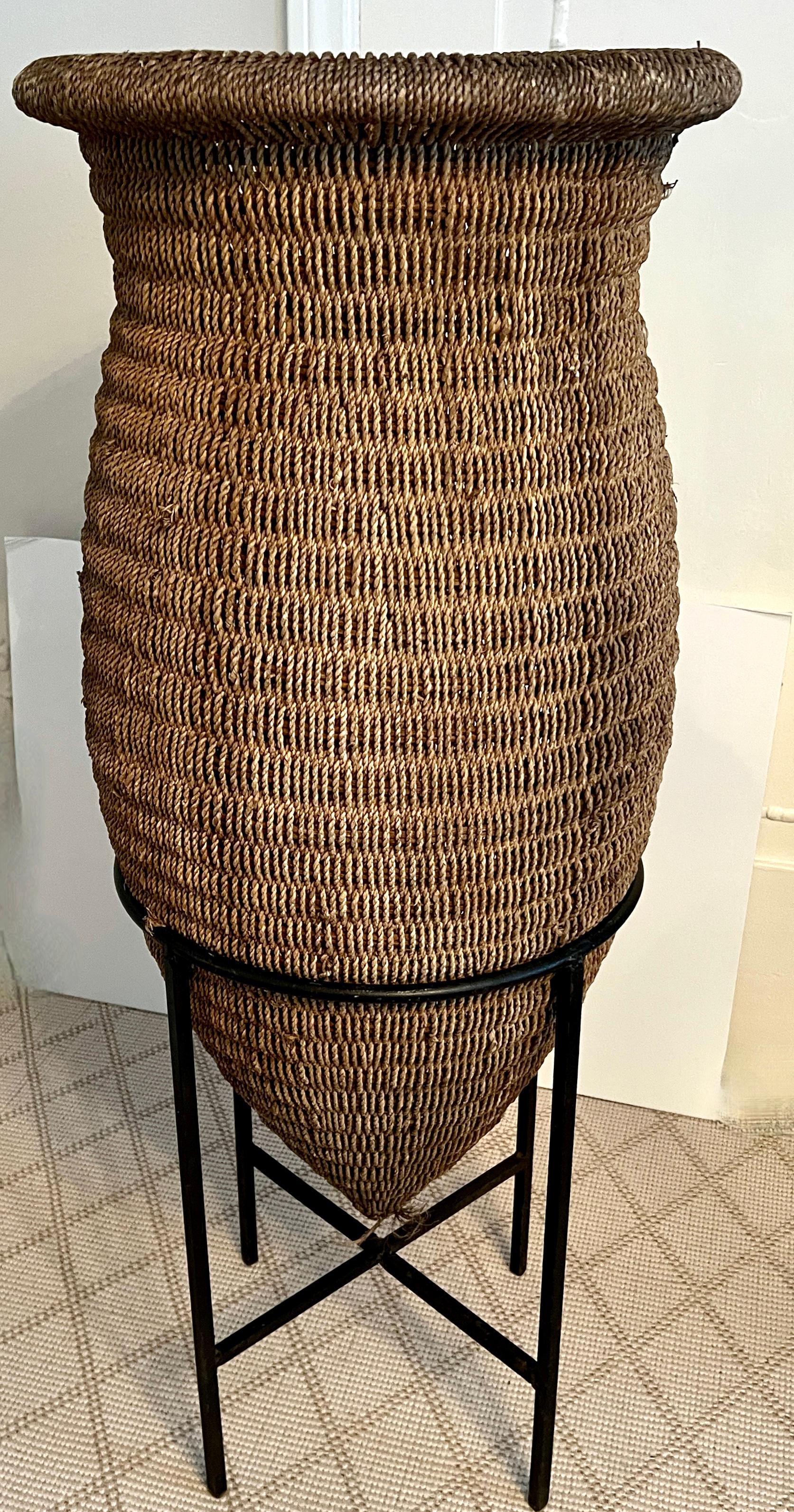 Cesta asiática de ratán tejida a mano sobre soporte de hierro forjado Hecho a mano en venta