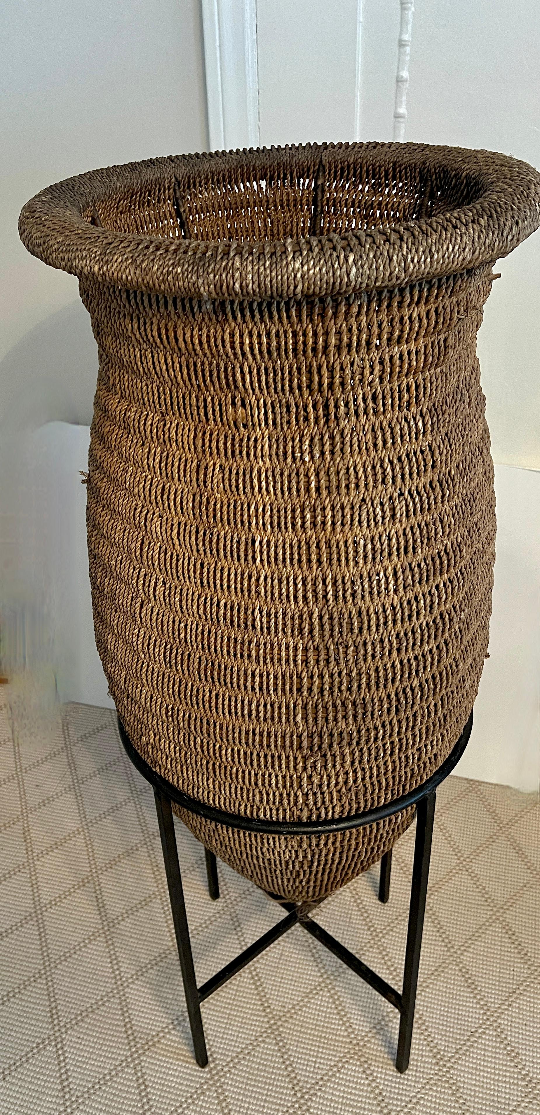 Cesta asiática de ratán tejida a mano sobre soporte de hierro forjado siglo XX en venta
