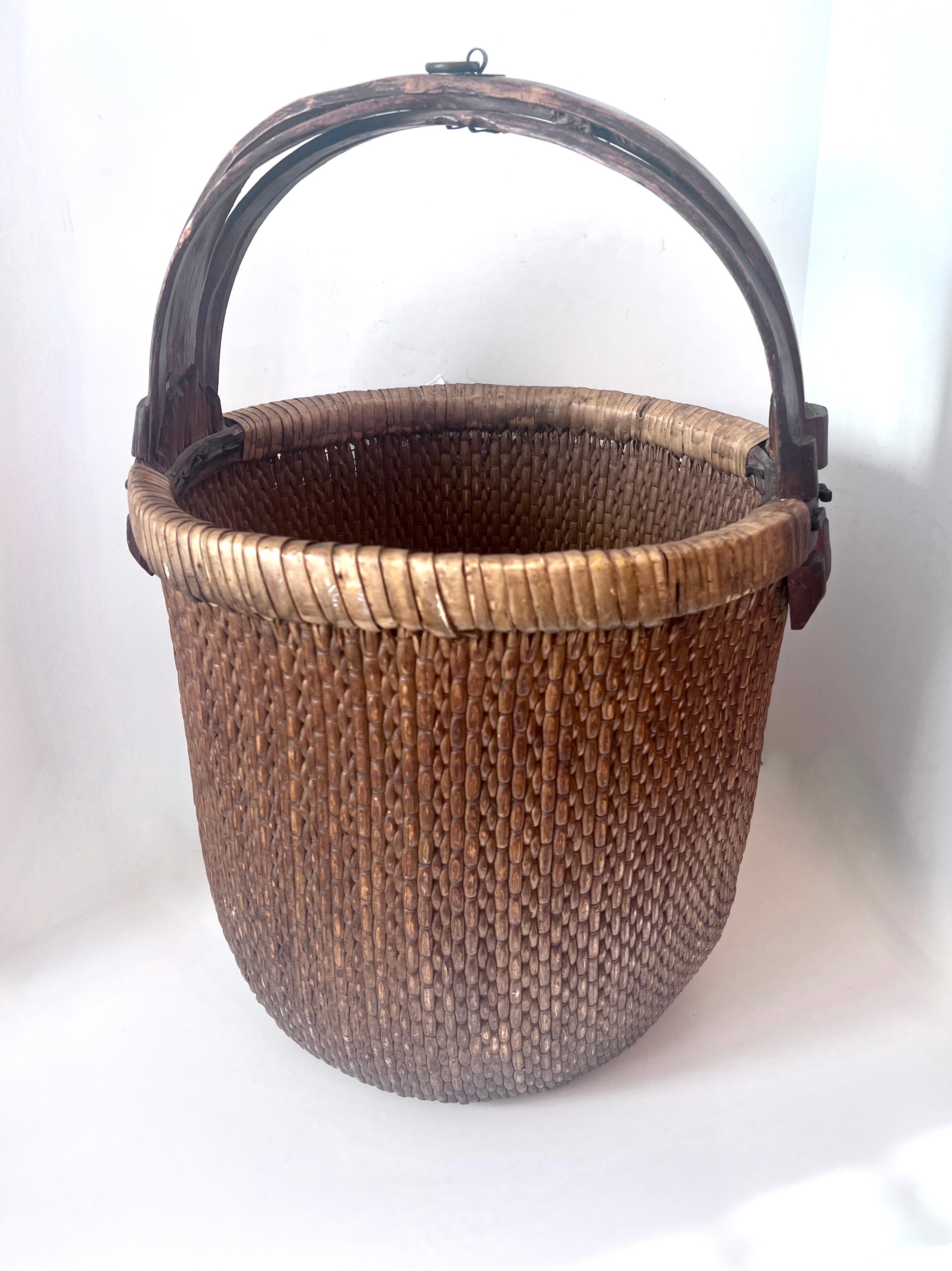 A hand woven and hand crafted Rice Basket.   Woven with Rattan and framed in wood with bamboo.   A very solid and well thought out and well made piece, late 19th / Early 20th Century Basket.

While it could be used for practical purposes, we like to