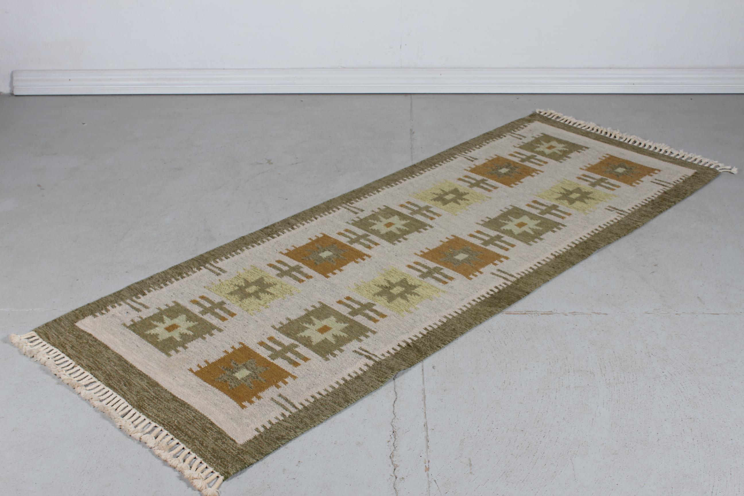 Vintage röllakan hand-woven woolen rug with fringes made in the 1970s most likely in Sweden

The rug shows a geometric pattern in dusty green, light yellow and reddish brown on a beige background. 

Very good and clean condition, no holes

Measures: