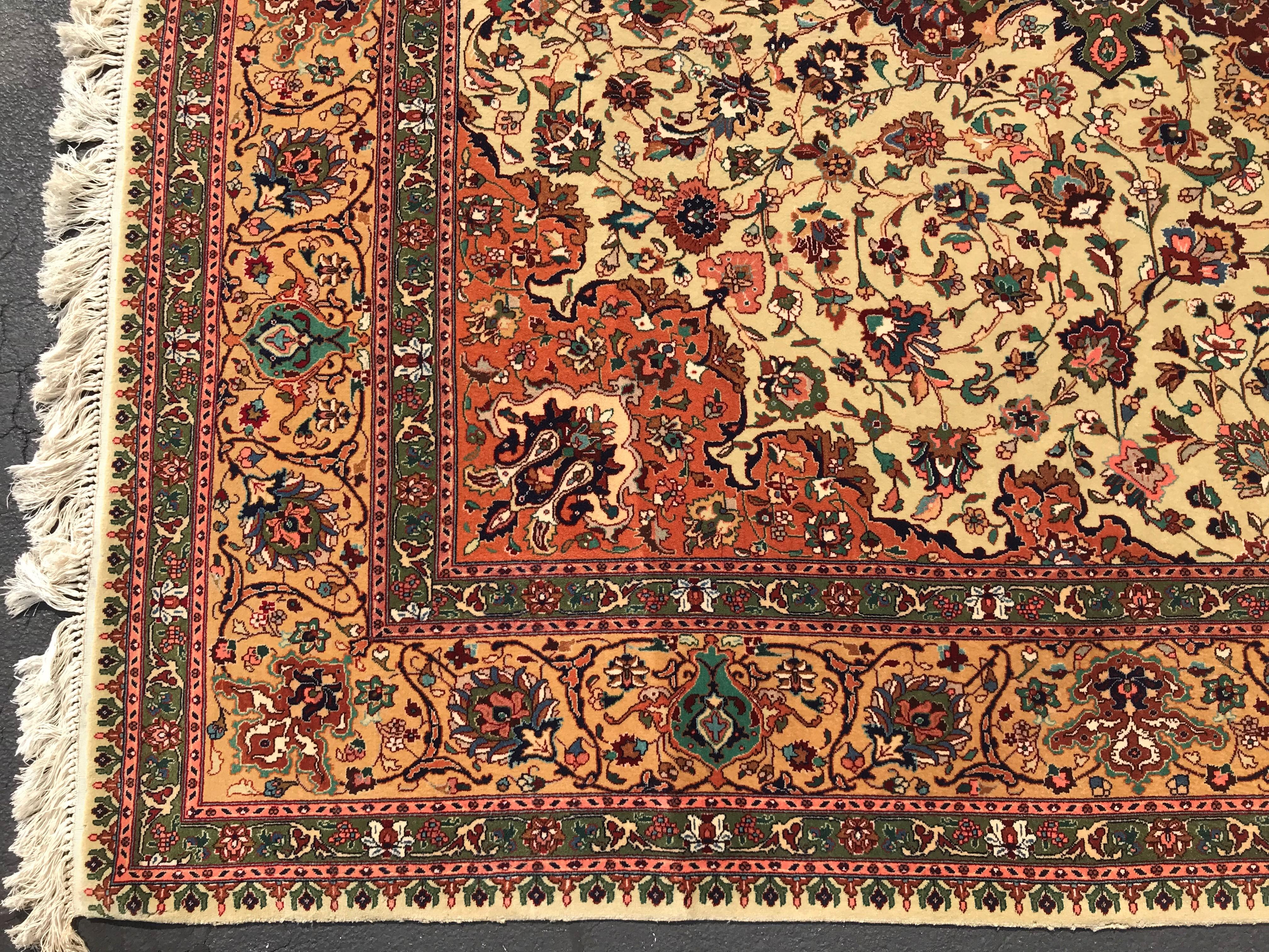 A fine Tabriz handwoven wool rug with central medallion on a cream field and gold border, circa 1960. Very good overall condition, tightly woven and made with vegetable dyes, with minimal imperfections and light overall wear from age and use.