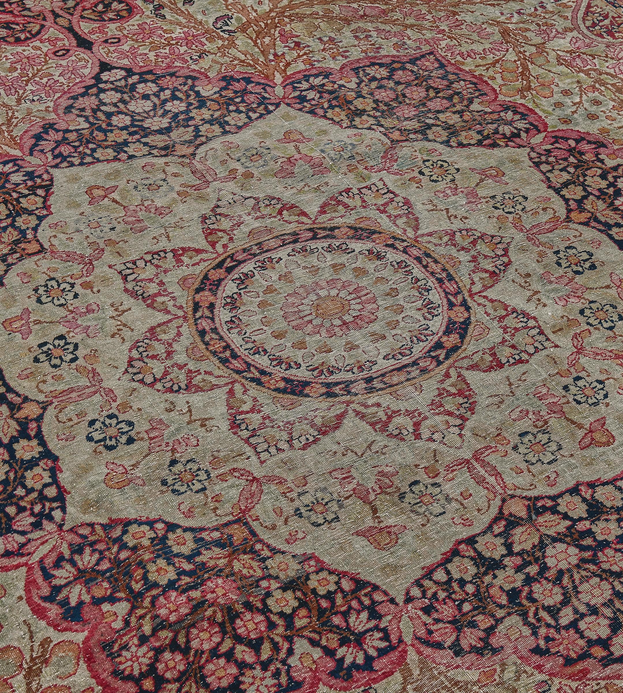 Questo tradizionale tappeto persiano Kerman tessuto a mano presenta un invitante campo dorato di fitti rami floreali che si irradiano da un medaglione arabesco imperiale, con maestosi pennacchi in mil-fleur, in un bordo in mil-fleur dorato, tra