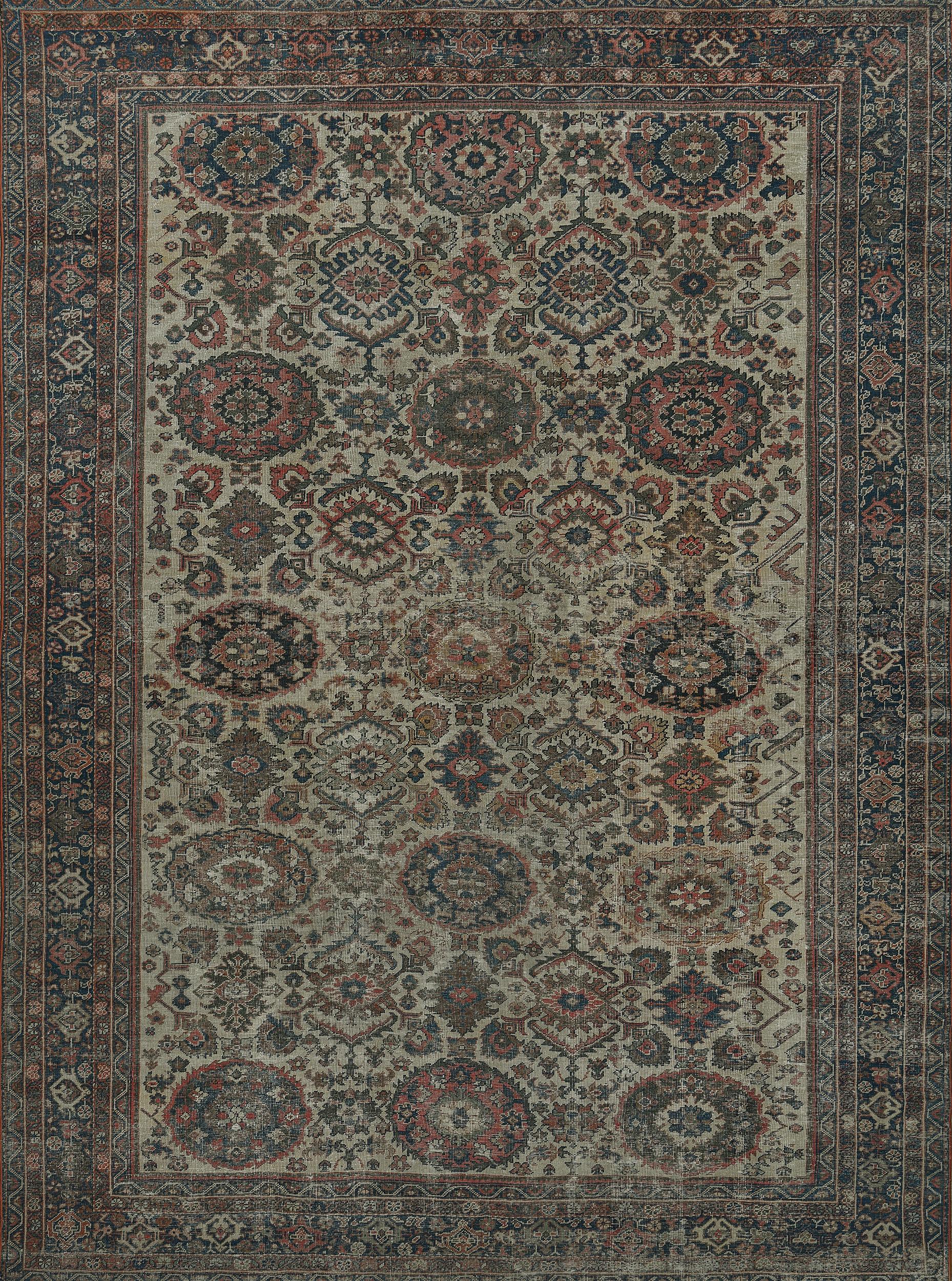 Questo tradizionale tappeto persiano Sultanabad Rugs, tessuto a mano, presenta un campo caldo color crema con pendenti di palmette regali e motivi geometrici, in un raffinato bordo di palmette color indaco, tra una profusione di righe floreali e
