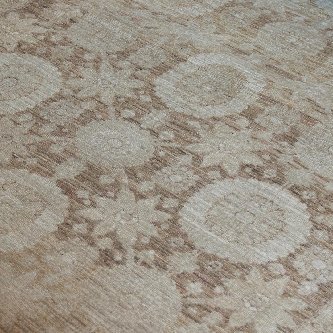 Dieser traditionelle handgewebte Teppich ist von einem persischen Täbris-Design inspiriert und hat ein mittelbraunes Feld mit einem gegenläufigen Blumen- und Medaillonmotiv in einer breiten, majestätischen, beigefarbenen Blumenbordüre.  100% Wolle. 
