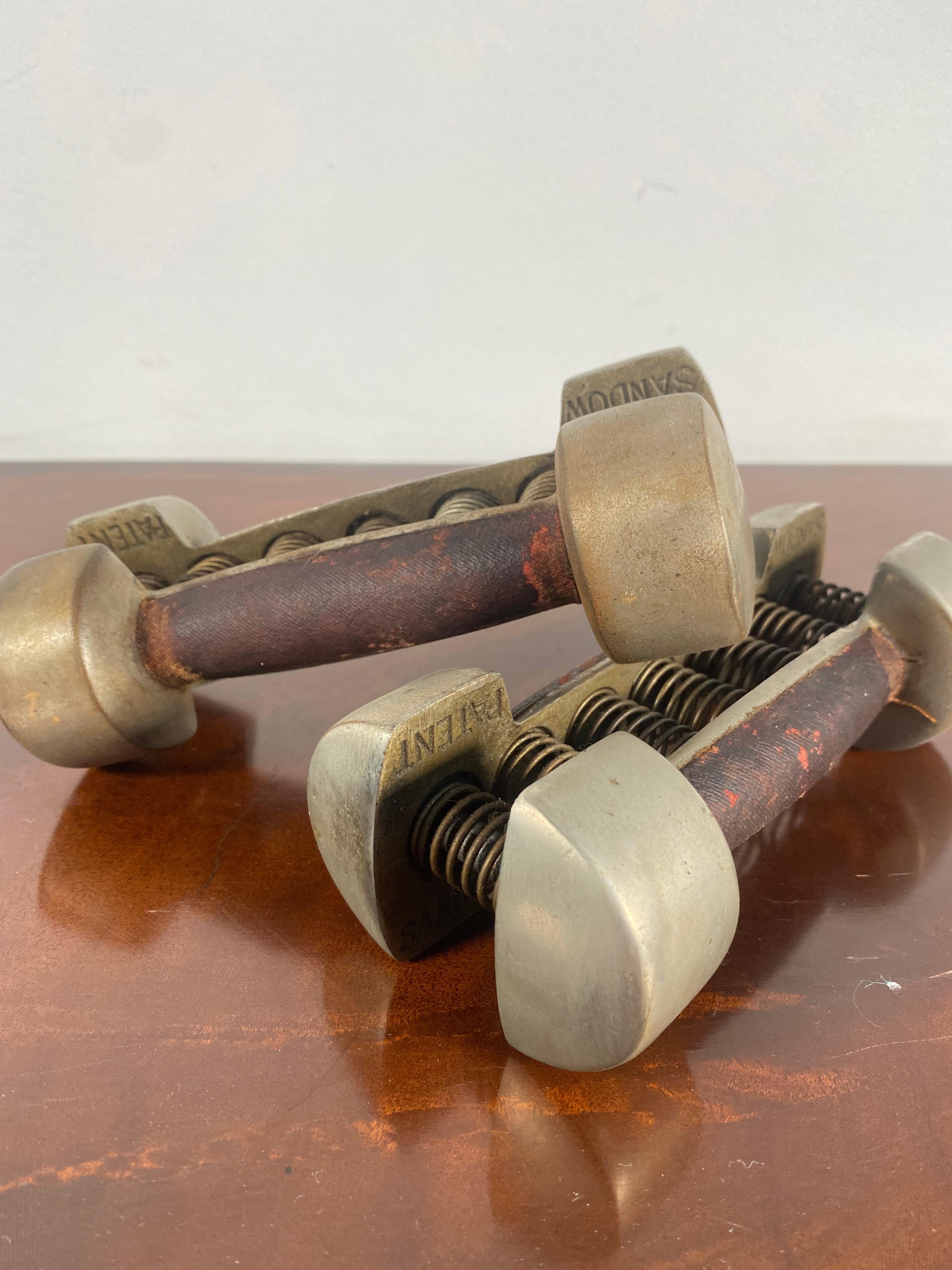 Coppia vintage di manubri con impugnatura a molla brevettati da Sandow, antichi attrezzi da ginnastica brevettati da Eugen Sandow (1867-1925), pioniere del bodybuilding. Le impugnature a molla nichelate sono complete di tutte le molle originali. I