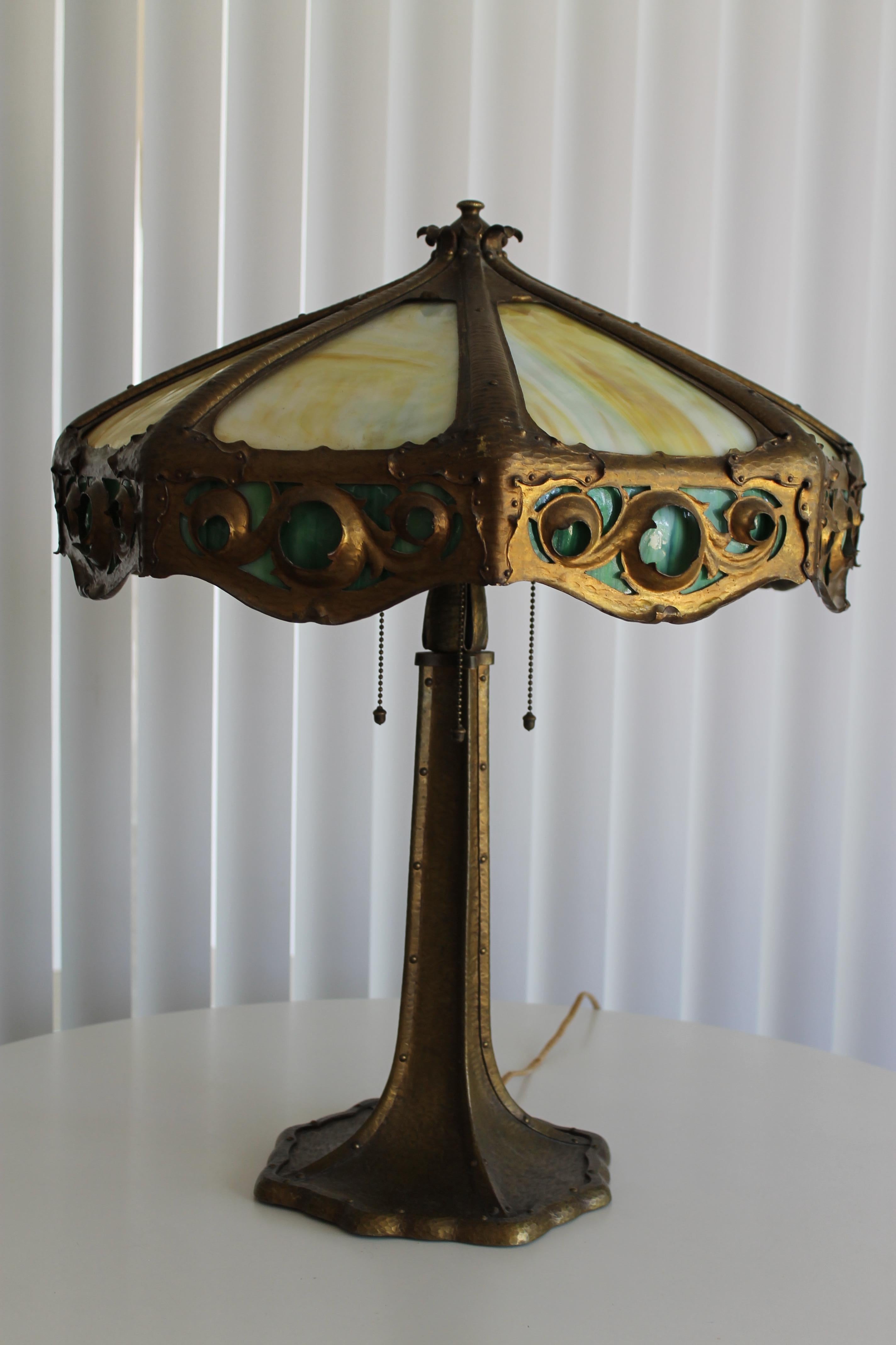 A large circa 1900s table lamp with original shade. All hand worked and riveted construction. Shade has eight yellow bent glass panels and eight green 