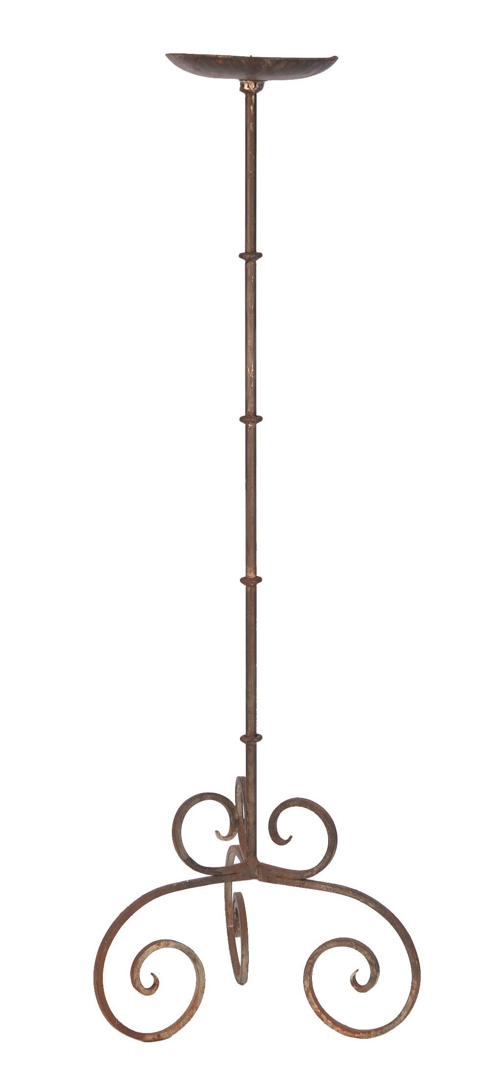 Tall wrought iron candle standing candle stiholder simple stem with scrolled tripod legs.