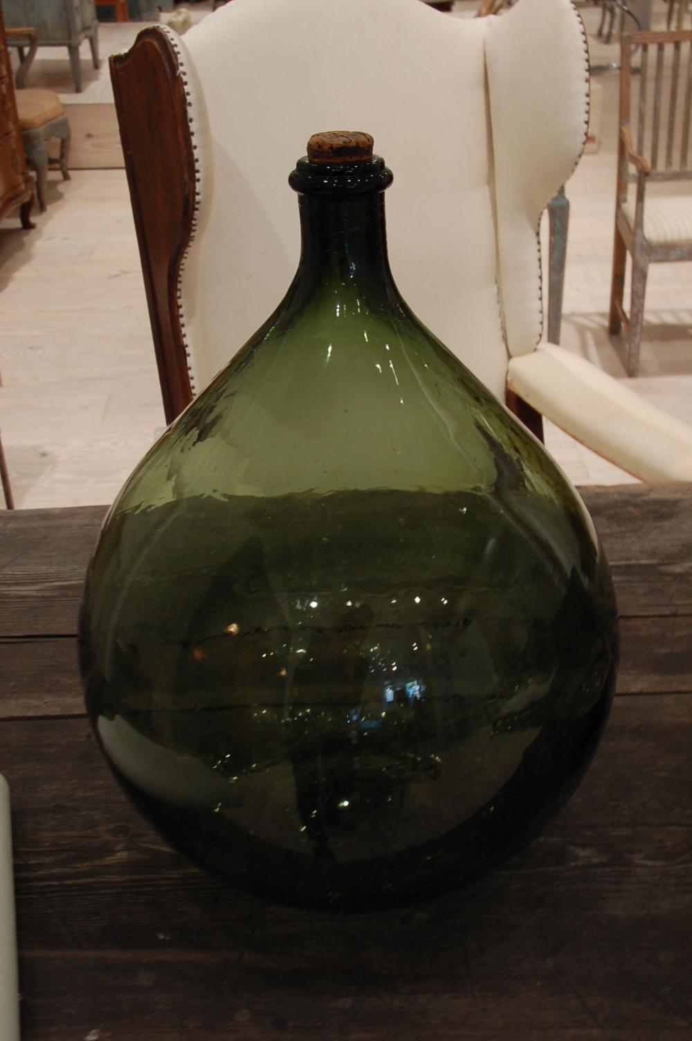 Handblown Swedish, 19th century, oversized green glass bottle with original cork, origin, Sweden, circa 1890.

We have a large selection of early, handblown glass in our gallery; this beautiful bottle can also be re-purposed into wonderful lamp.
 
