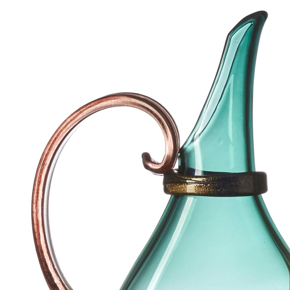 Designed to fit on narrow mantles, ledges and window sills, each decorative Flat Pitcher is blown and pressed by hand during the glassblowing process to inspire layered displays of translucent color. Sculpted handle, wrap, and solid foot details