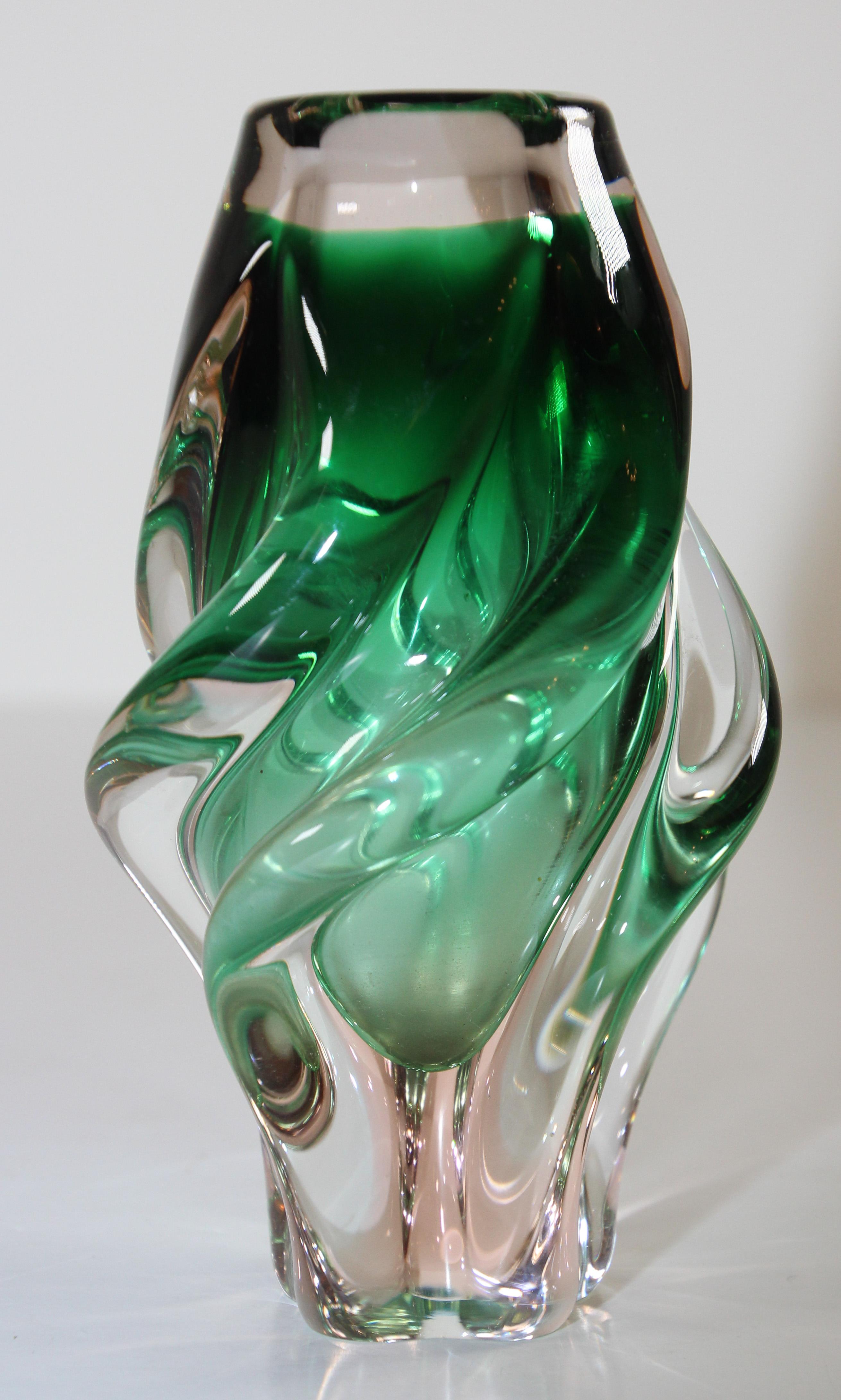 Vase en verre d'art soufflé à la bouche de style Murano en forme de torsion verte.
Le talentueux artisan récupère les techniques traditionnelles de soufflage du verre de Murano, en Italie, en utilisant des pigments pour donner à ce vase des nuances