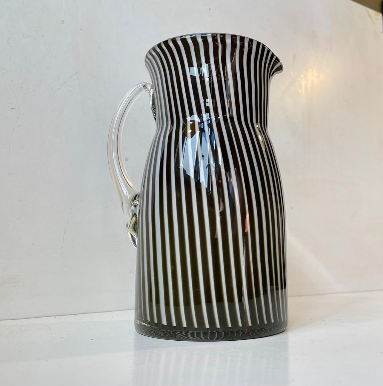 Handblown Venetian Glass jug/pitcher for milk or water. It is executed in cased black and white pin-striped glass and features opaline glass to its interior. Made in Murano Italy circa 1980-85. Beautiful, clean and intact vintage condition.