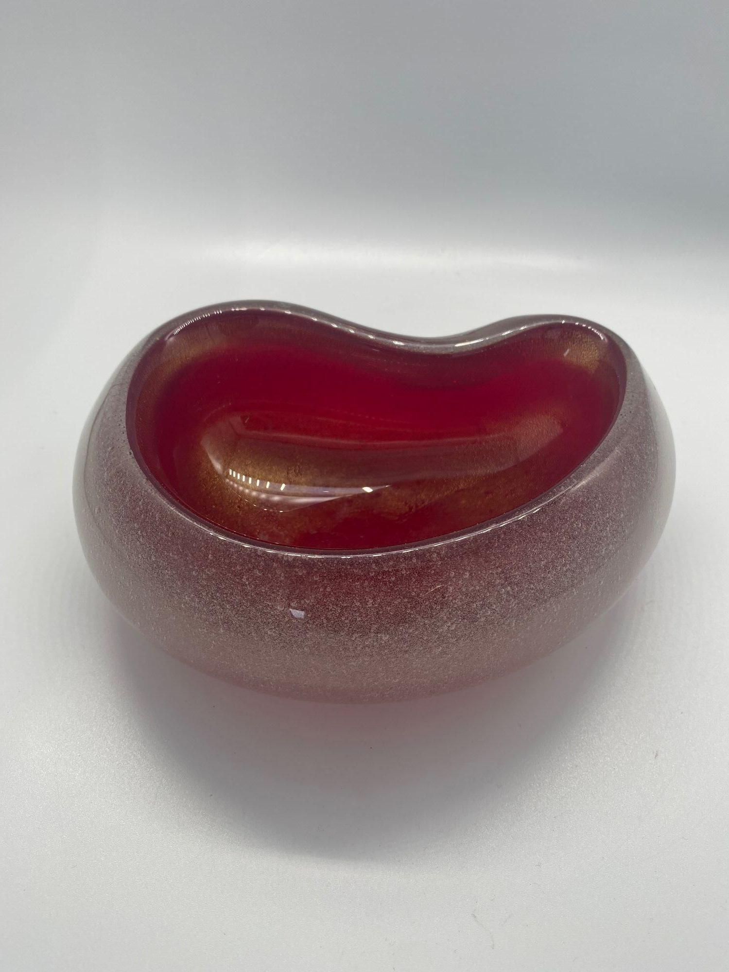 Handblown cherry red biomorphic Murano glass ring tray featuring a bubble decorated clear exterior with a red glass interior.

Italy, 1960