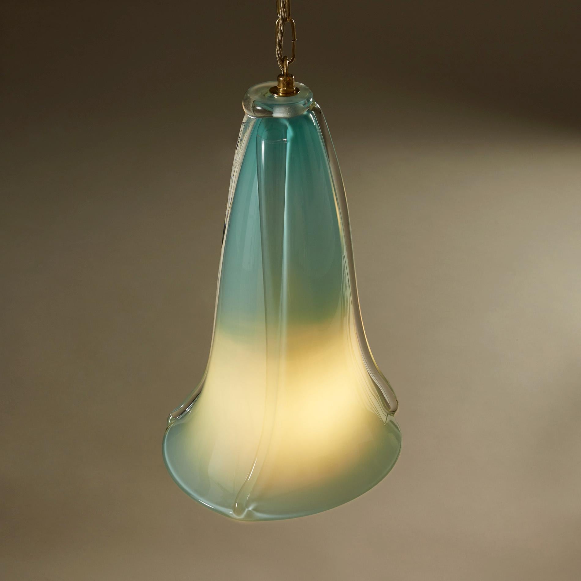 Handblown glass pendant in a soft aqua marine colour. Substantial Murano glass curved to an organic fluted shape, each with three clear glass ribs running the length of the glass. Brass fittings, chain and ceiling rose. Exudes a soft mood