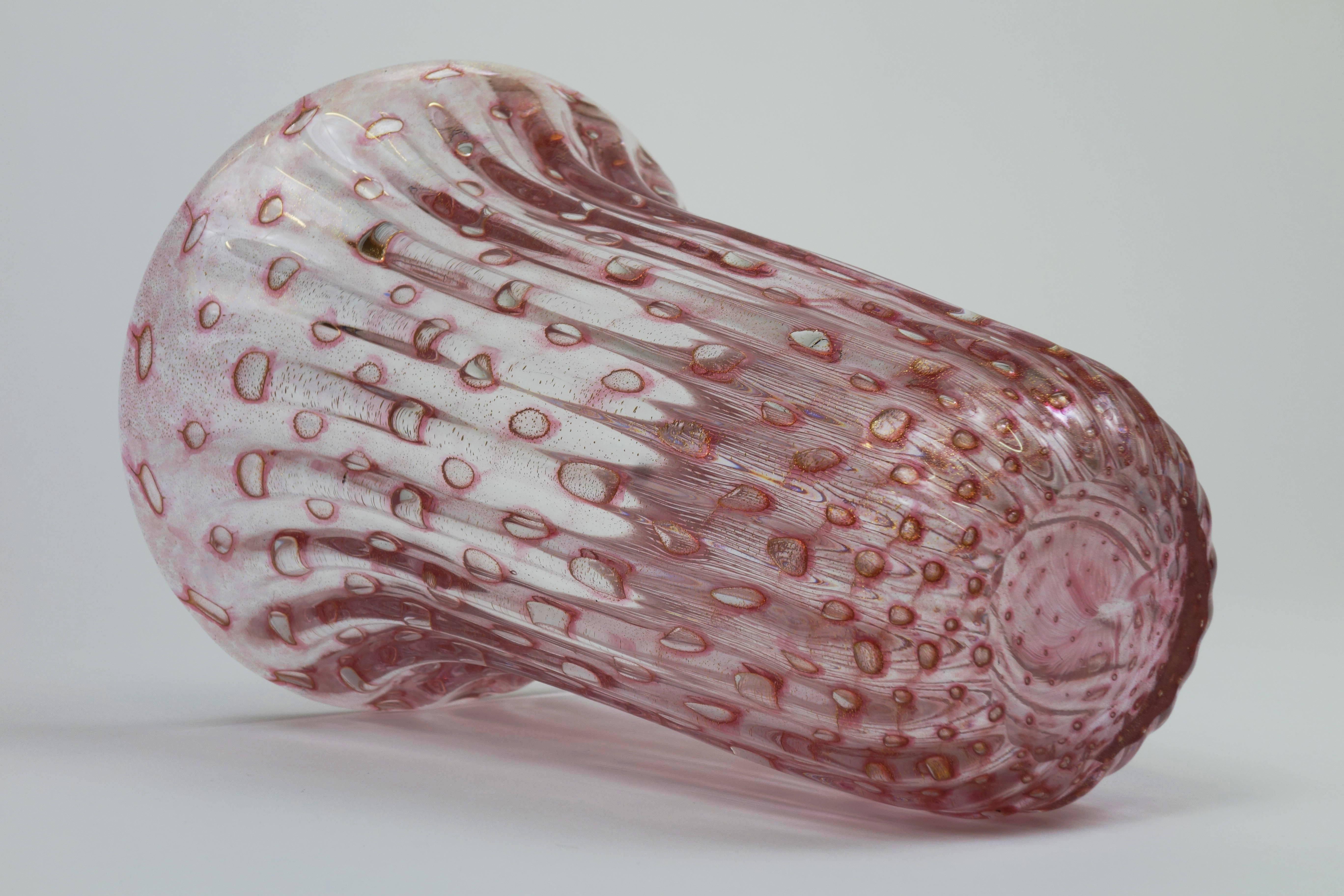 Jarrón de cristal de Murano soplado y estriado de Fratelli Toso, Murano, Italia, años 50. Cuerpo rosa oscuro con inclusiones de burbujas de aire iridiscentes y motas de oro polvera de 24 quilates. Un objeto cuyas cualidades son especialmente