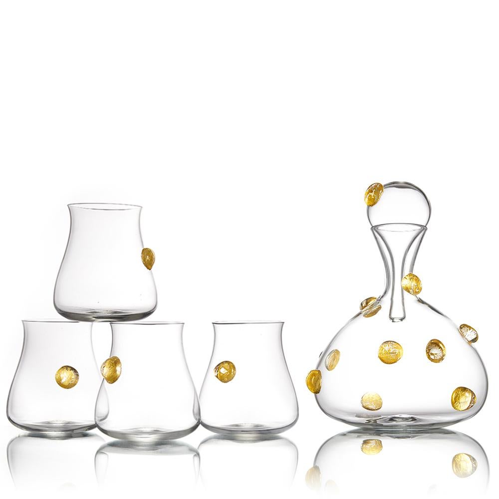 The Festa collection of hand blown glass decanters and barware features a celebratory, golden confetti pattern of optic glass dots. Encased gold leaf is magnified by the raised dot pattern, and decorates the surface of each carafe and tumbler. A