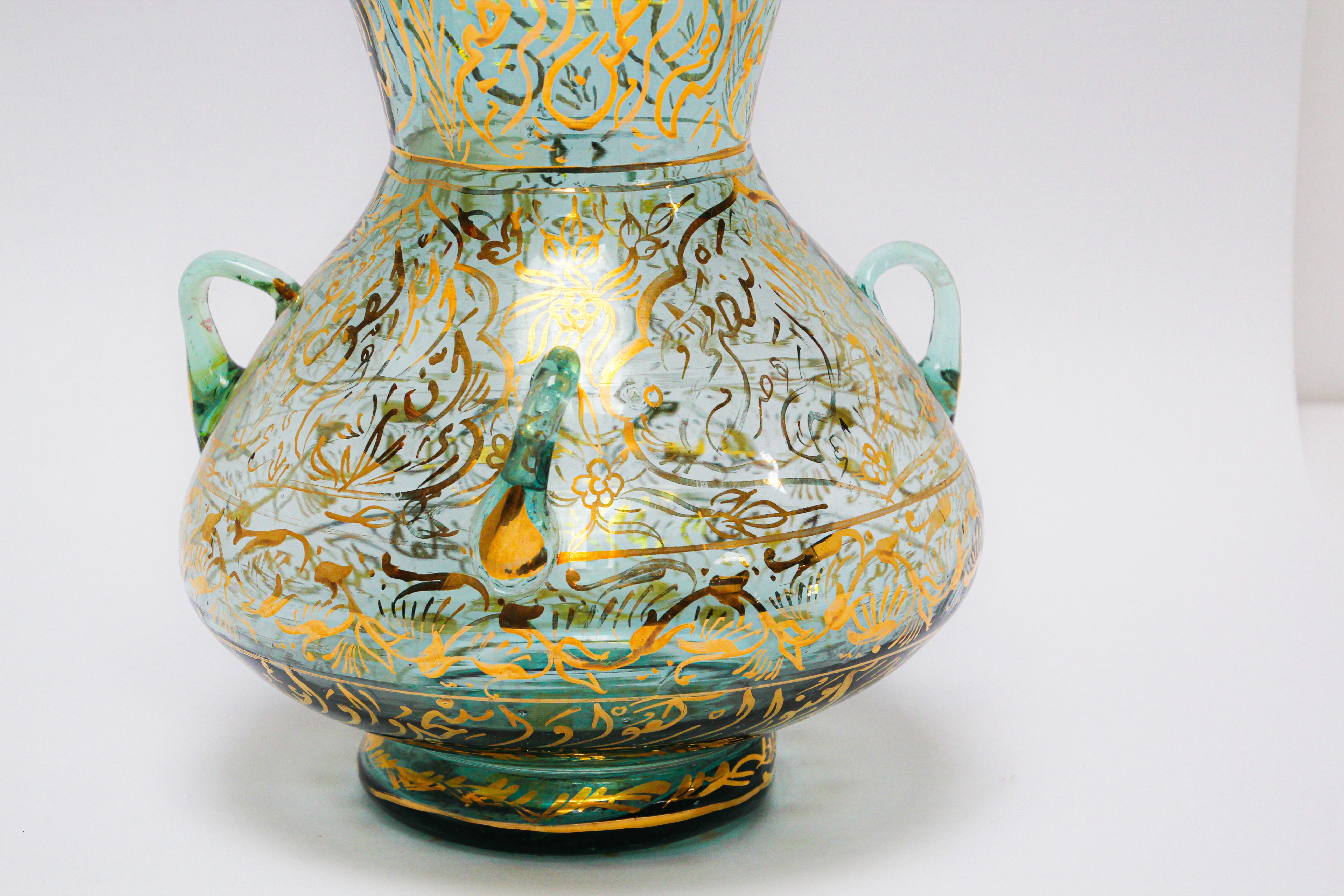 Middle Eastern Mosque lamp in the Islamic tradition, Mameluke style hand painted blown clear glass with gilded calligraphic inscriptions.
Dimensions: 15in. height x 11in. diameter, mouth opening 9.5in.
These were used as oil lamps.
Large round