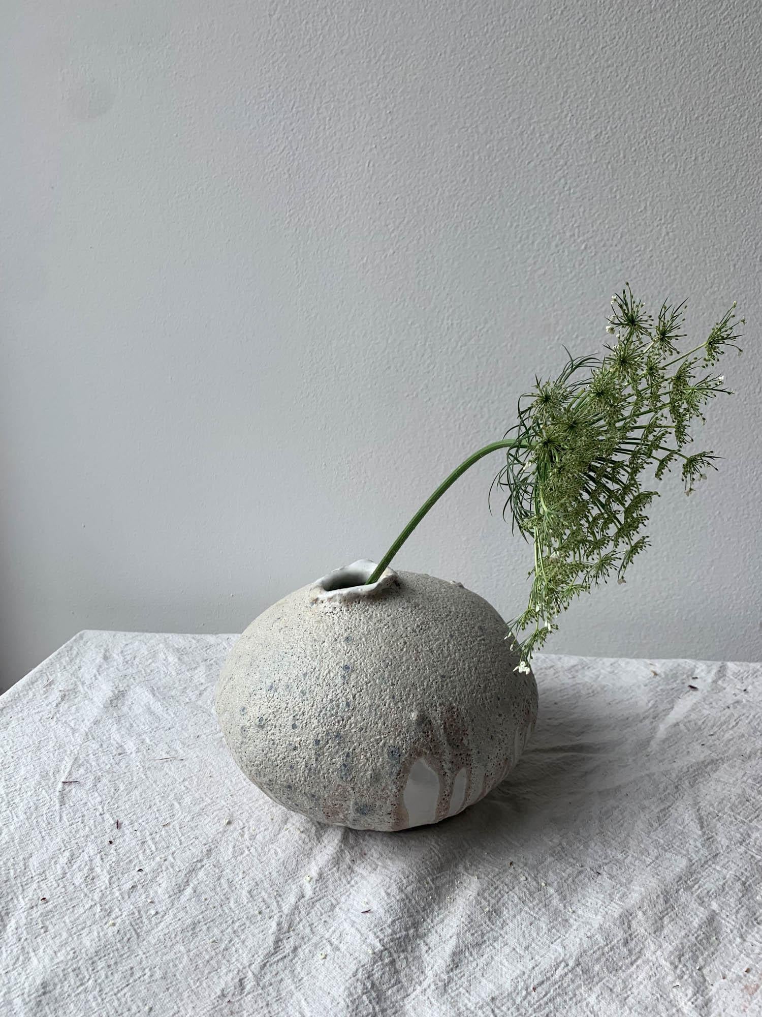Handbuilt organic modern moon vase made from a groggy clay body covered layers of glossy and matte white glaze, and a heavily textured lava glaze. Each vase is made by hand in our Brooklyn studio, and no two are ever exactly alike. The moon vase is
