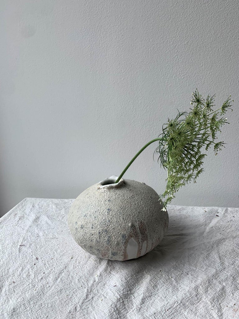 Handbuilt organic modern vase made from a groggy clay body covered layers of glossy and matte white glaze, and a heavily textured lava glaze. Each vase is made by hand in our Brooklyn studio, and no two are ever exactly alike. The moon vase is