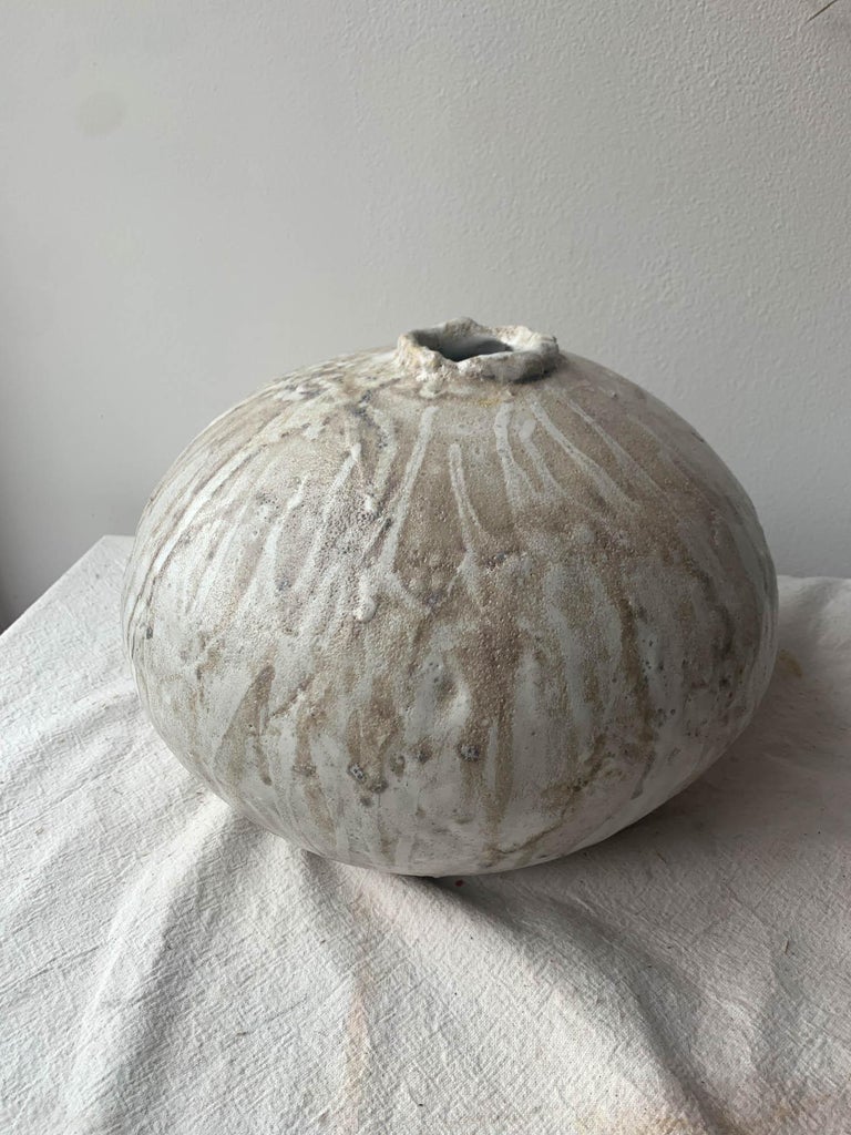 Handbuilt organic modern vase made from a groggy clay body covered layers of glossy and matte white glaze, with a heavily textured glaze on top. Each vase is made by hand in our Brooklyn studio, and no two are ever exactly alike. The moon vase is