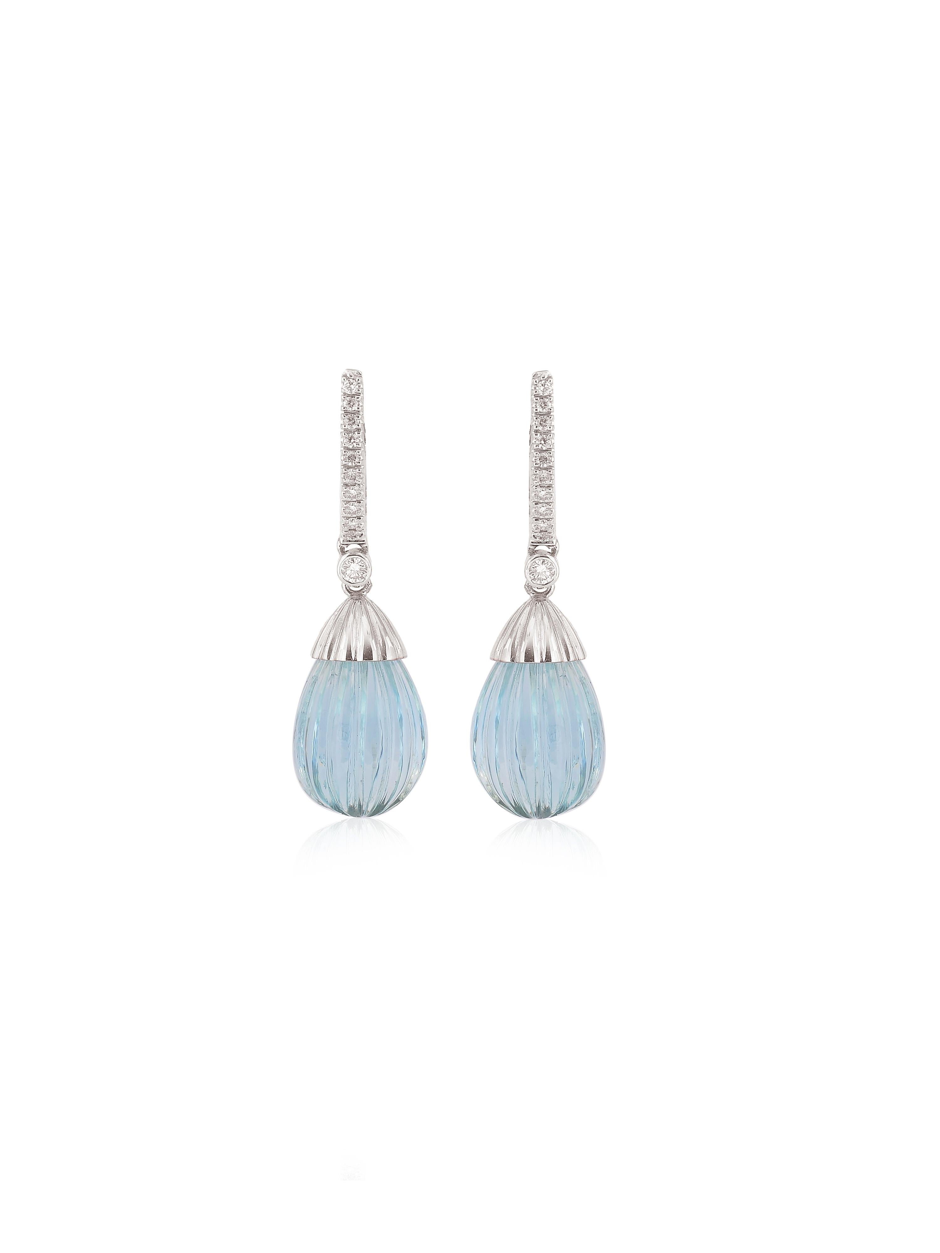 A pair of beautifully hand carved Aquamarines hanging from a diamond hoop all made in 18k white gold.
Its a clean Aquamarine with top color and once suspended one can see the luster even better!
The pair of Aquas weigh 19.93 carats. 

