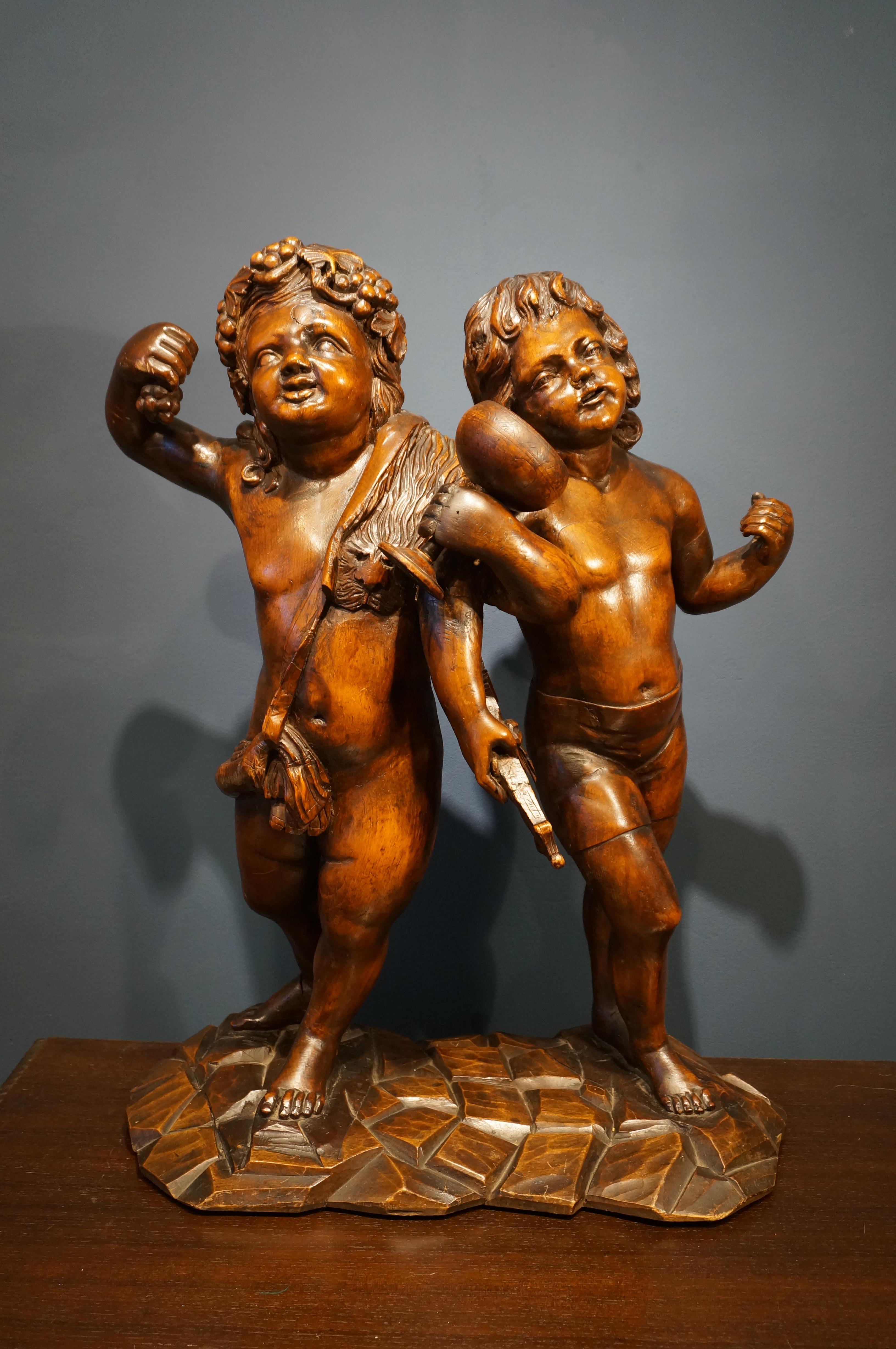 Handcarved baroque wooden sculpture depicting the two accomplises Bacchus and Amor.
Bacchus is wearing a grapevine in his hair and holds up a bunch of grapes. A jaguar skin is draped around his shoulder and in his left hand he holds a goblet.