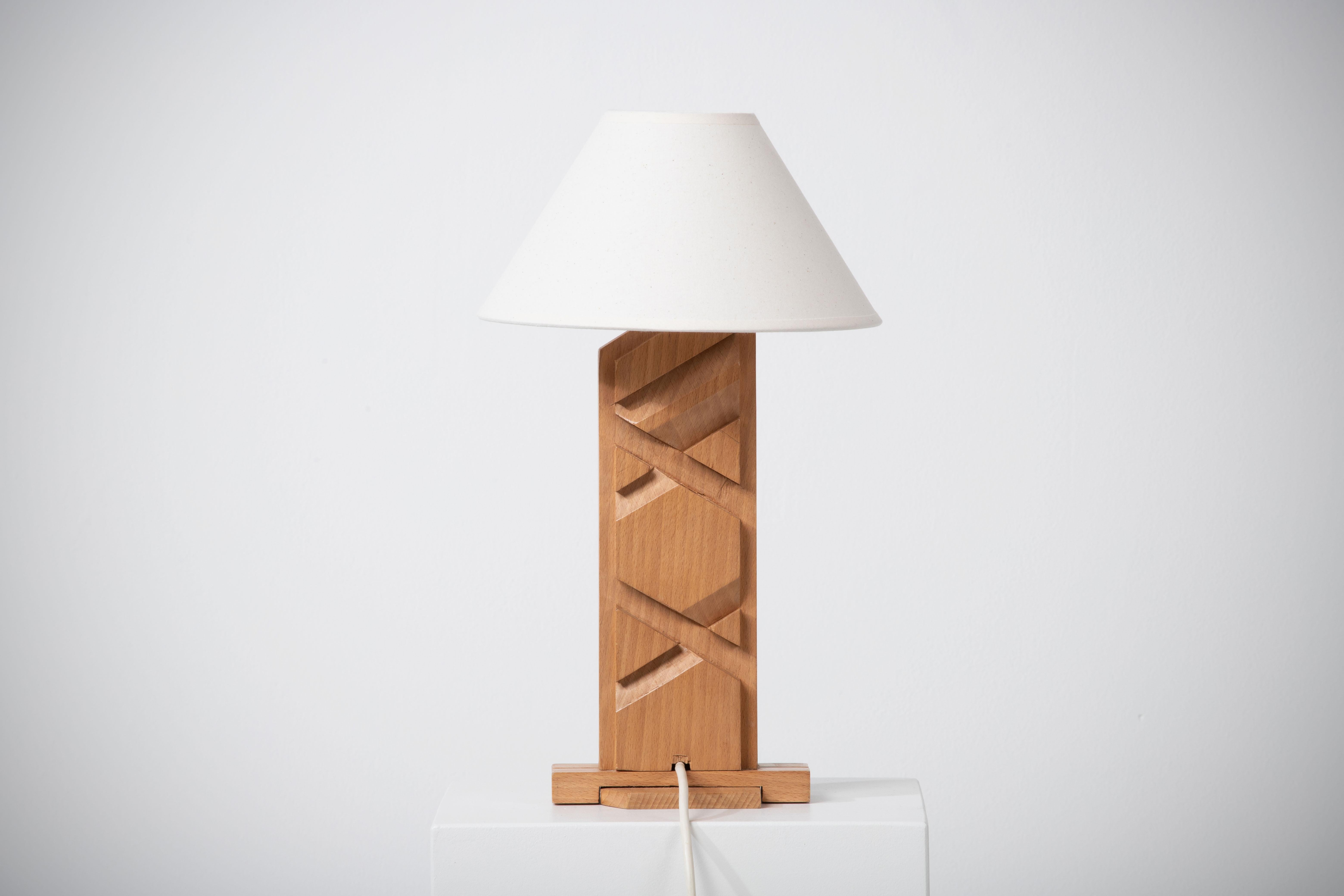 Introducing an exquisite hand carved midcentury French lamp that effortlessly captures the essence of timeless beauty and craftsmanship. Crafted with meticulous attention to detail, this lamp showcases elegant straight lines and is made from