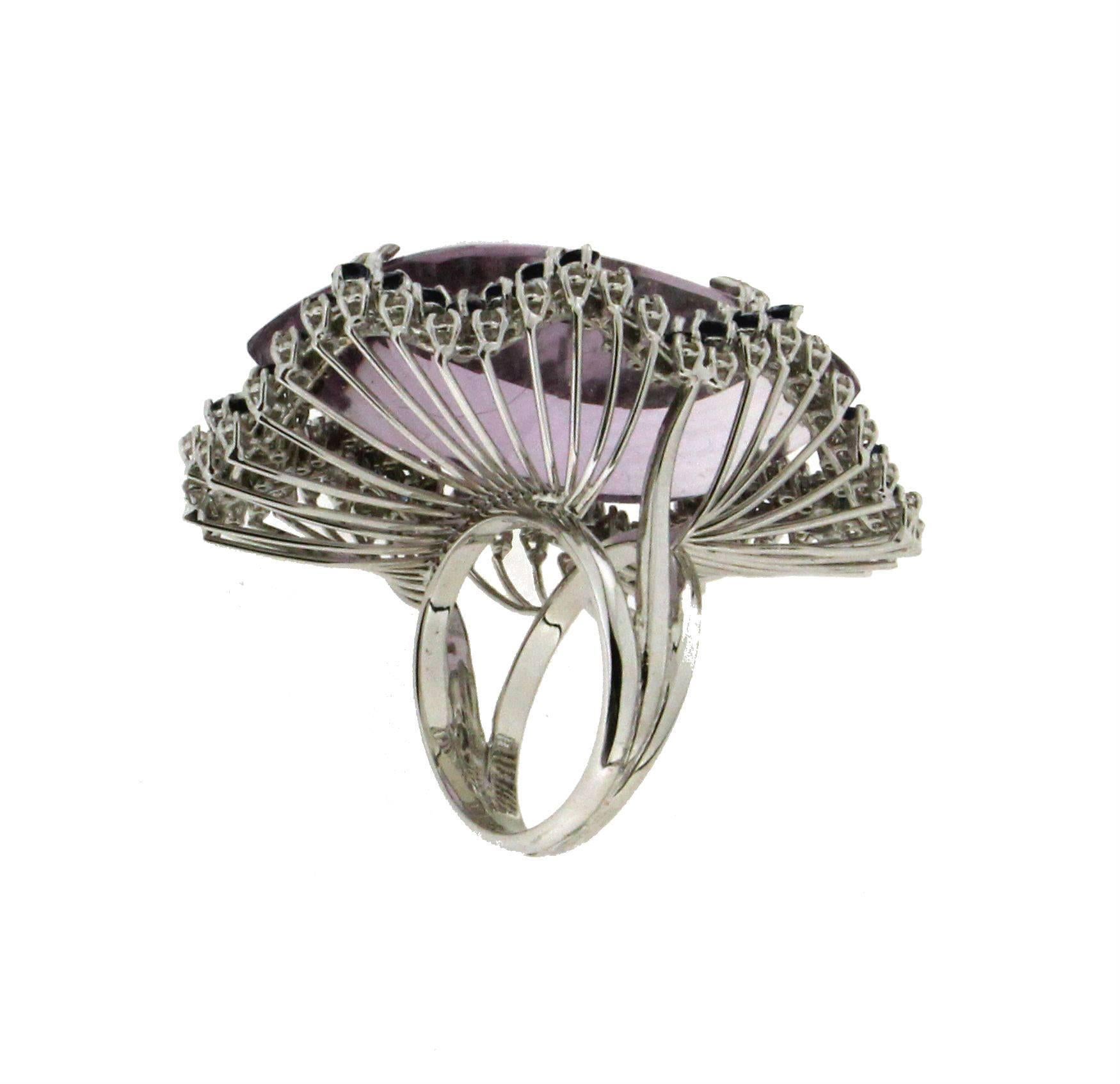 18 karat white gold cocktail ring.Handmade by our artisans assembled with amethyst, diamonds and sapphires.

Ring total Weight 30 grams
Diamonds weight 1.02 karat
Sapphires weight 2.36 karat
Amethyst weight 60 karat
Ring Size 8 Us
(all rings are can