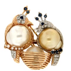 Broche artisanale oiseaux en or blanc et jaune 14 carats avec perles, diamants et saphirs