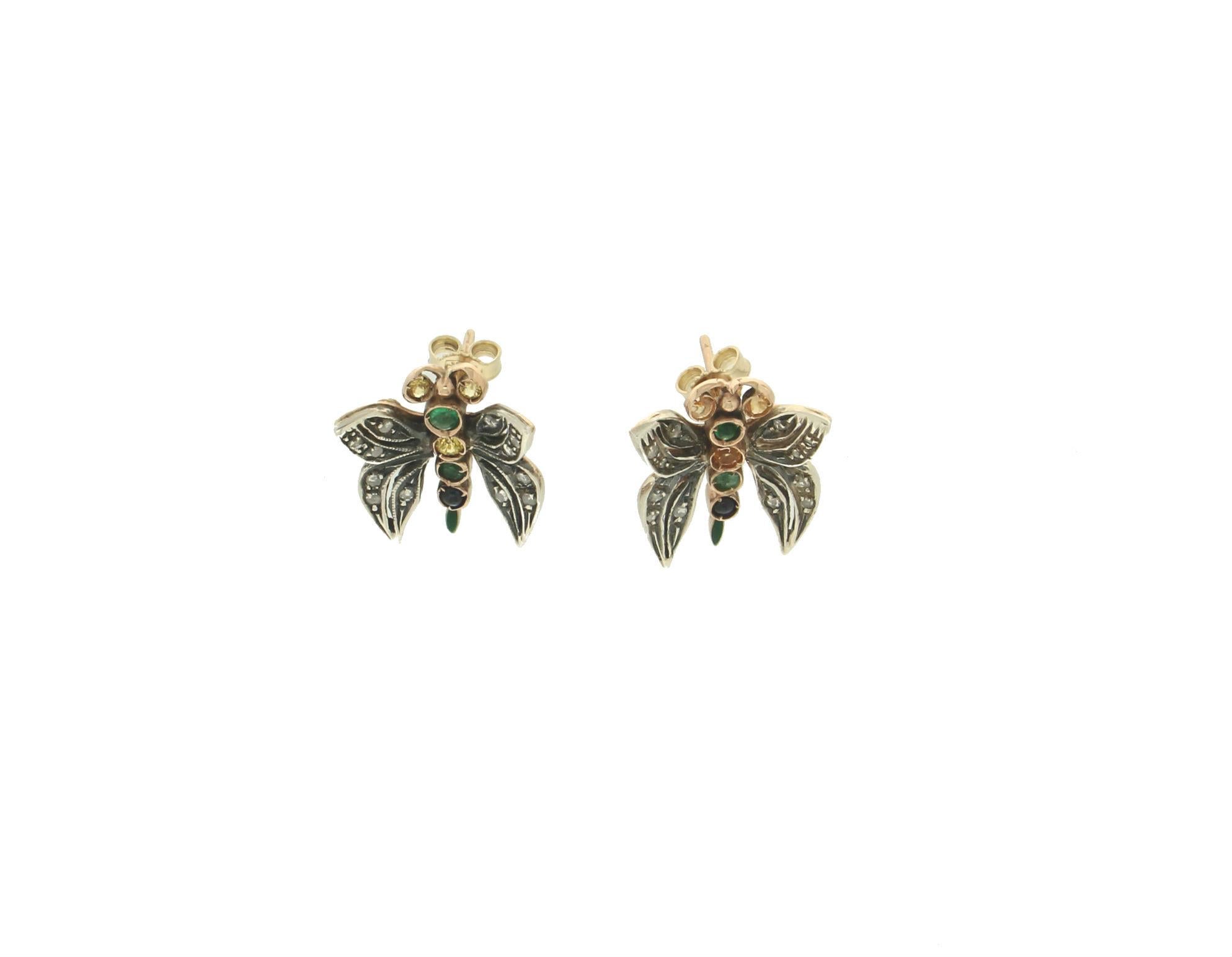 Precious butterfly-shaped earrings in 14 karat yellow gold and 800 thousandths silver made entirely by hand by our skilled artisans.
The earrings are adorned with old rose-cut diamonds on the wings and natural sapphires and emeralds along the