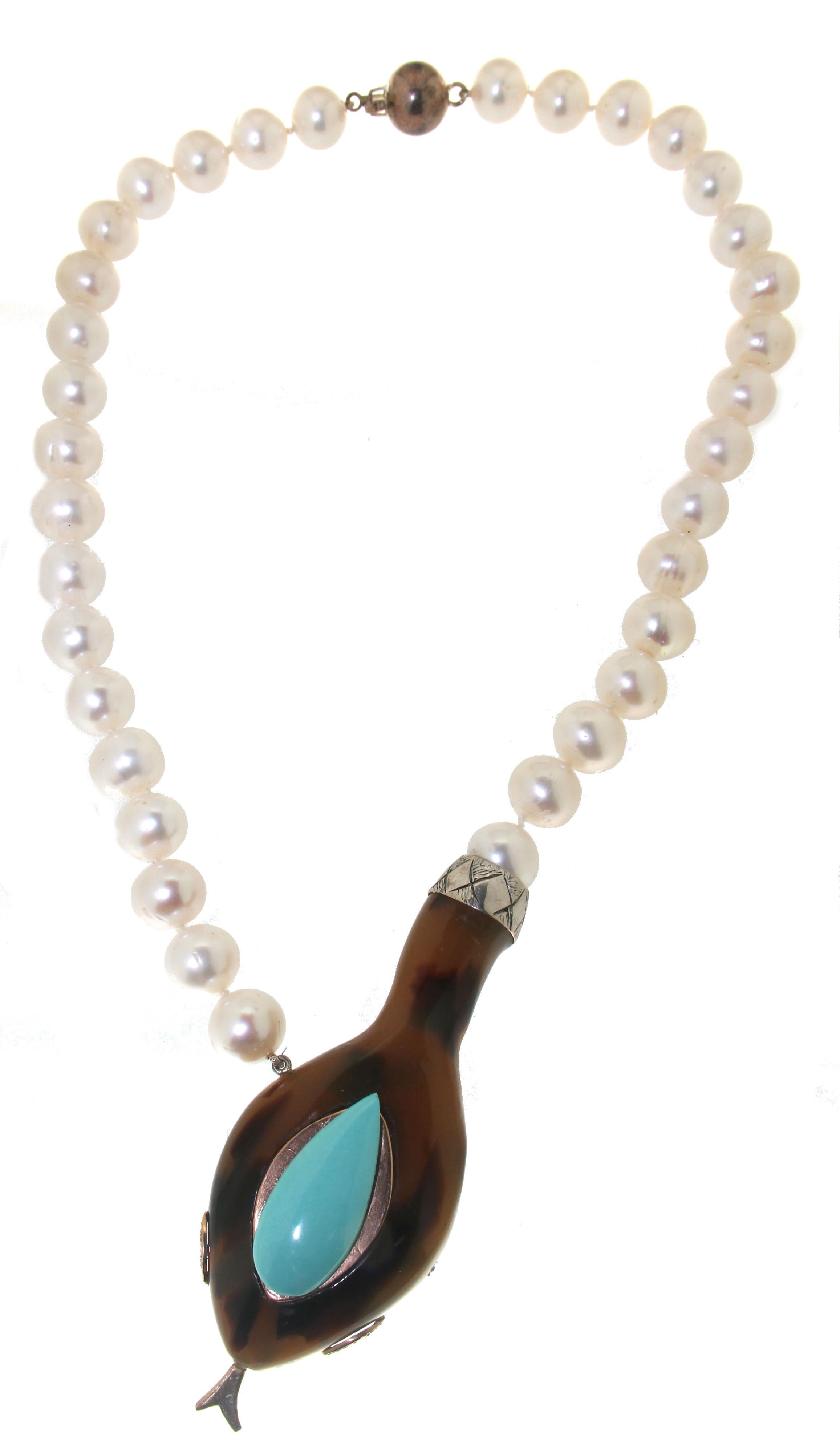 9 karat yellow gold and 800 thousandths silver drop necklace. Handmade by our craftsmen assembled with freshwater pearls,turquoise.diamonds and galalith snake.

Pearls size 11 mm
Diamonds weight 0.06 karat
Turquoise weight 2.10 grams
Necklace total