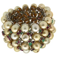 Manchette artisanale en or blanc 18 carats avec perles, émeraudes, rubis et diamants