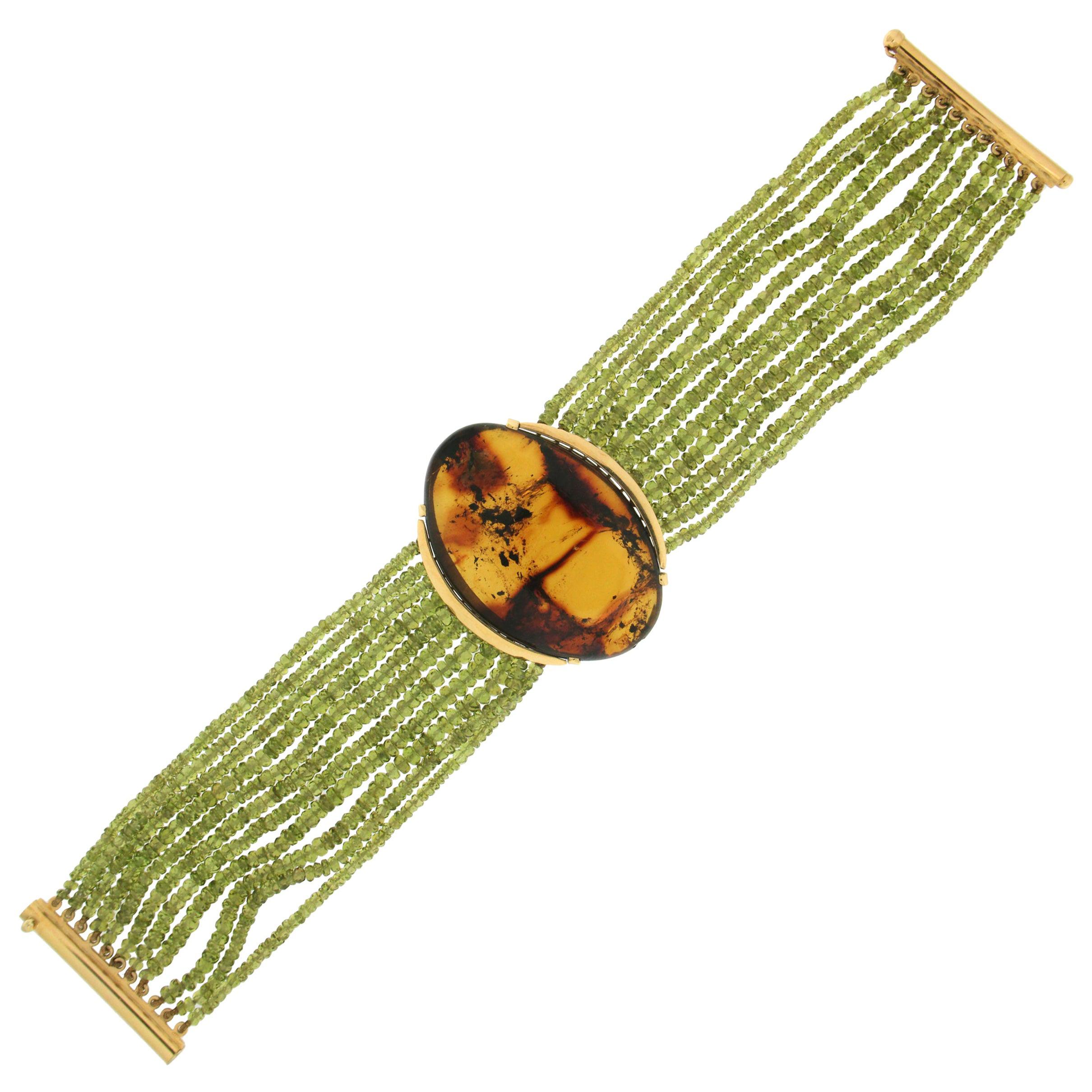 Bracelet manchette artisanal en or jaune 18 carats avec péridots et ambre