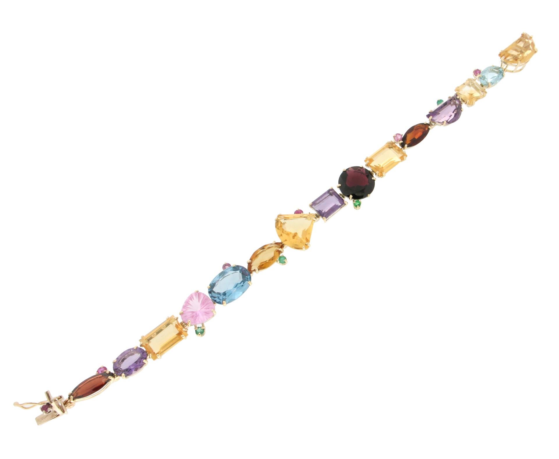Magnificent bracelet made entirely by hand by our expert craftsmen in 14 Carat yellow gold composed of gems of various types of cut. Amethysts and garnet citrines, while emeralds and rubies surround it.

The bracelet has a total weight of 23.10
