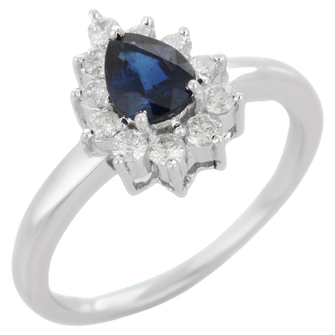 Handgefertigter Ring aus 14 Karat Weißgold mit blauem Saphir im Birnenschliff und Halo-Diamant 
