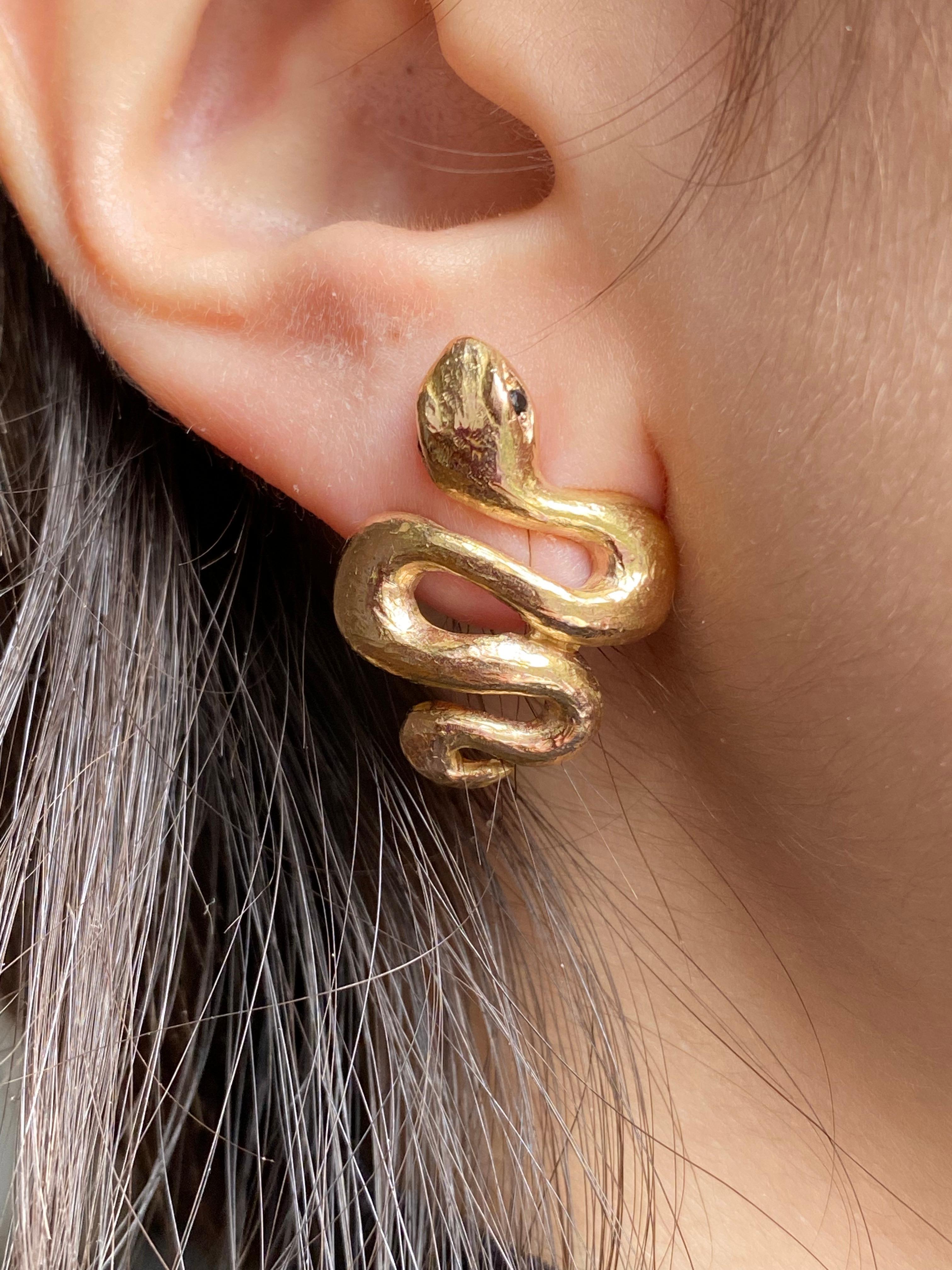 Rossella Ugolini Collection Handcrafted 18K Hammered Yellow Gold 0.004 Karat Black Diamonds Snake Stud Earrings. 
A beautiful pair of stud earrings openly inspired by the ancient painting of the Etruscan people who lived Italy before the Romans.