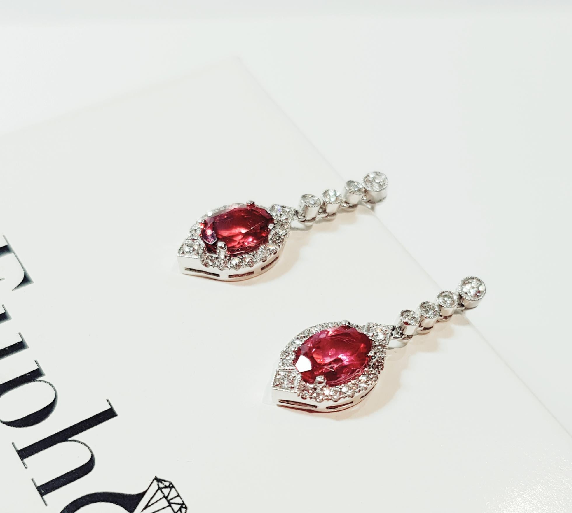 Handcrafted 18ct white gold earrings set with 2 x oval imperial red vibrant Spinel AAA grade and collection quality round brilliant cut diamonds.   
Euphoria Jewels only embraces rare ,exotic , intense gemstone colours that appeal to the inquisitive
