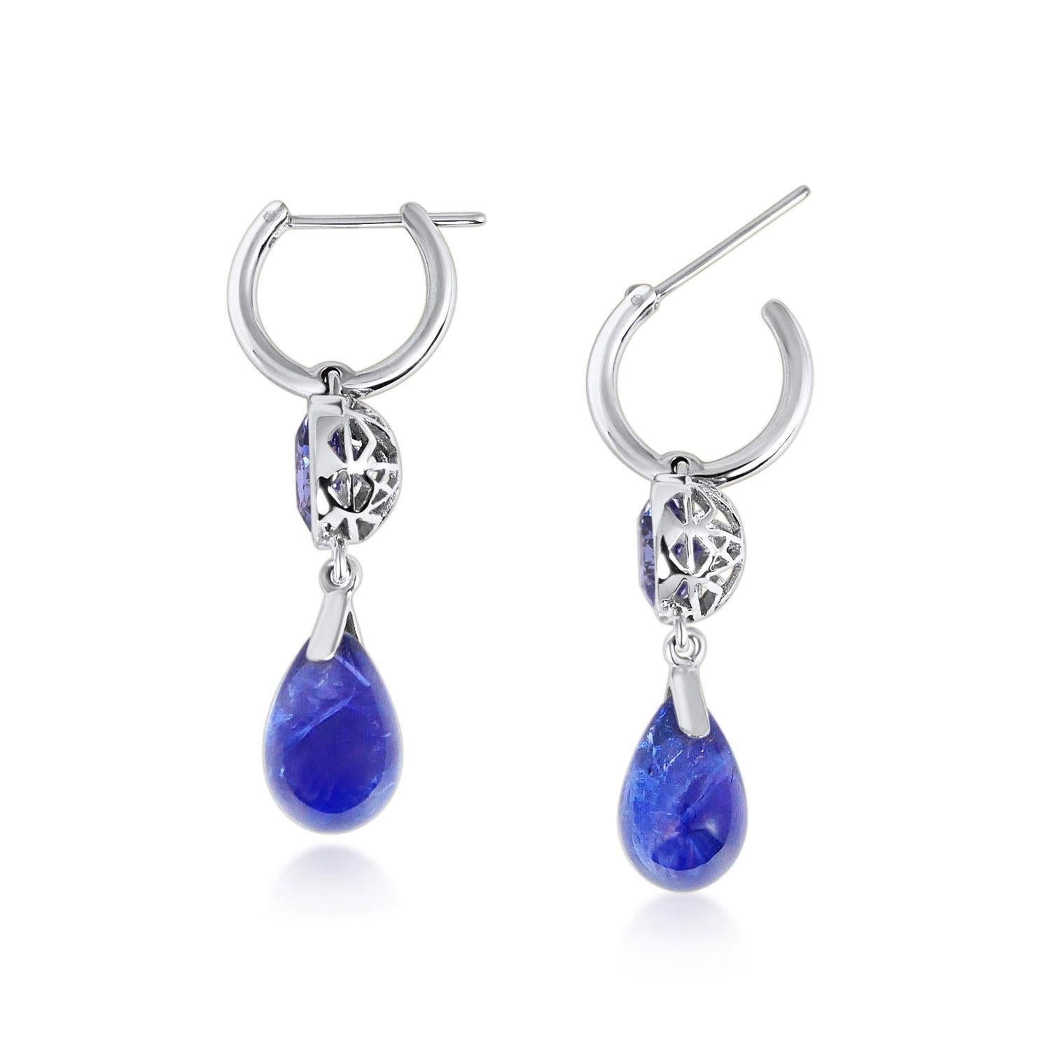 Handcrafted 2.80 & 10.95 Carats Tanzanites 18 Karat White Gold Drop Earrings. Dancing drops carved in Tanzanite under a set of round cut 8mm Tanzanite stones encased in our iconic hand pierced gold lace to let the light through. A diamond has been