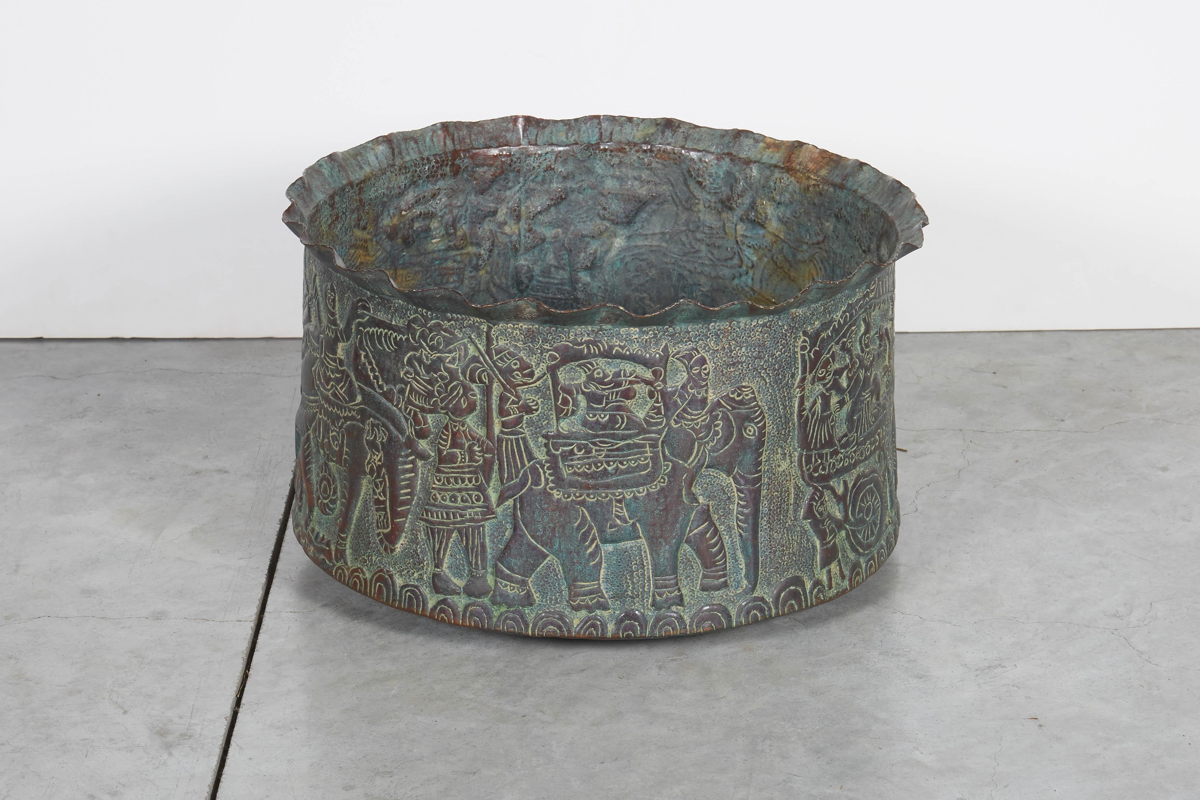 An expertly handcrafted copper repousse grain storage bowl with extraordinarily detailed images of elephants and other local folklore from Bangladesh. The lovely soft green patina will complement any space.
M2031.