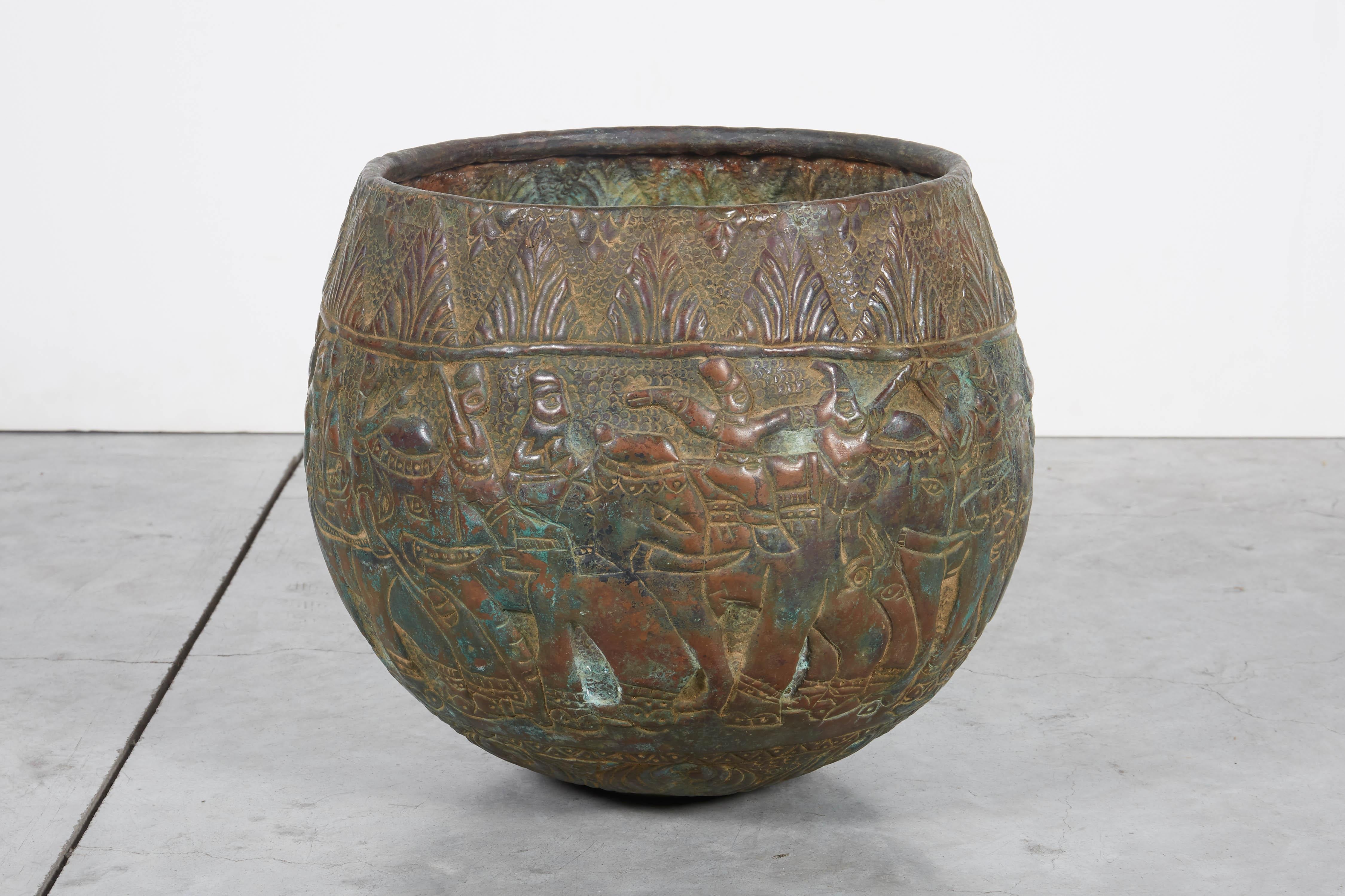 An expertly handcrafted copper repousse grain storage bowl with extraordinarily detailed images of elephants and other local folklore from Bangladesh. This gracefully shaped bowl has a lovely soft green patina that will complement any space.
M2031.