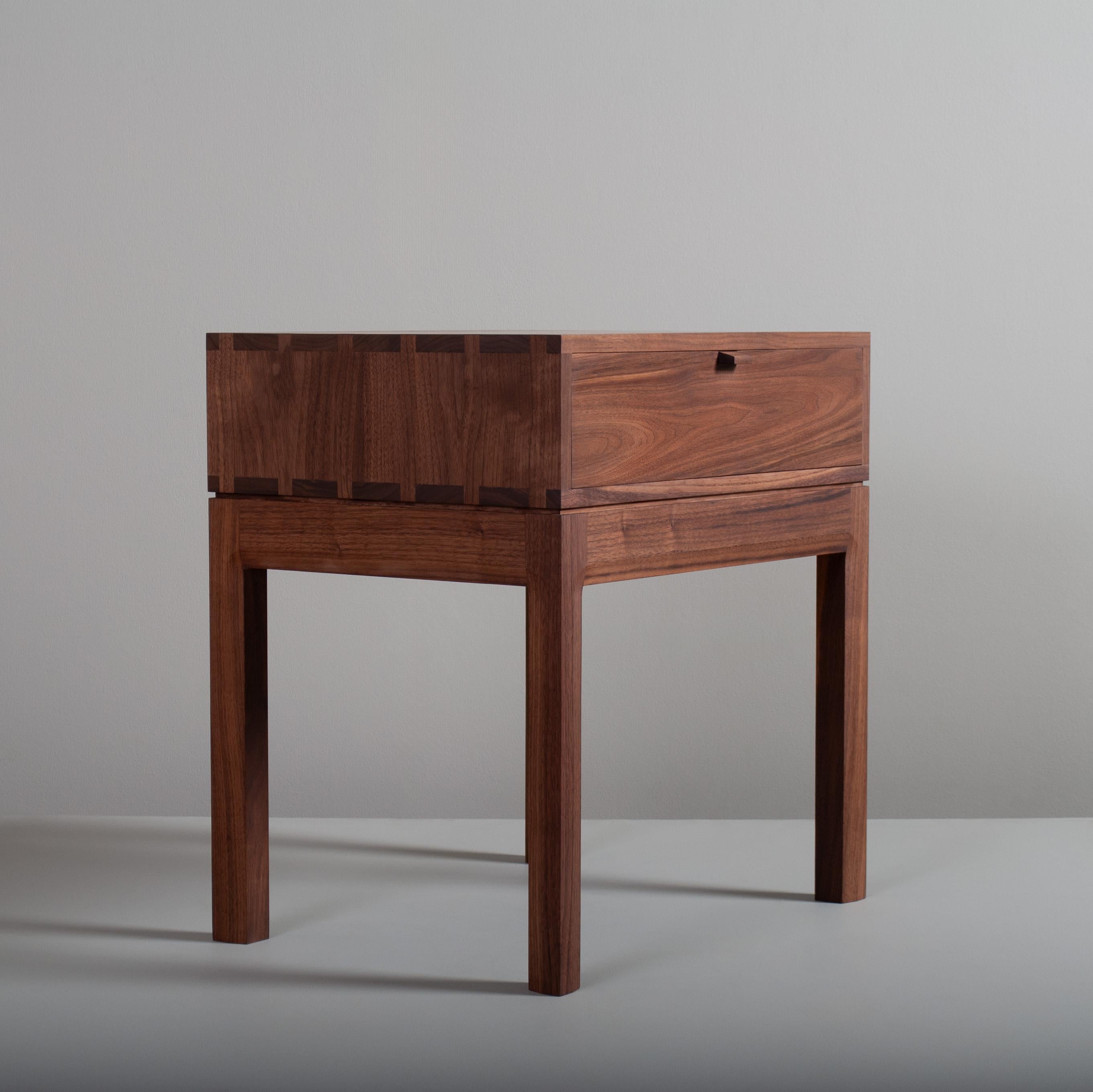 American black walnut hand-crafted nightstands or end tables in a midcentury modernist design. These are constructed from the finest American black walnut with the inner dovetailed jointed traditional drawer carcass in prime English Oak. The main