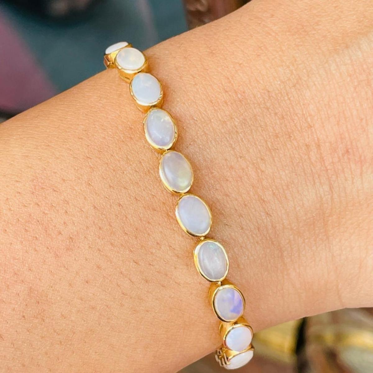 This Handcrafted Bezel Set Oval Opal Tennis Bracelet in 18K gold showcases 7.45 carats endlessly sparkling natural Opal. It measures 7 inches long in length. 
Opal can help you attract the right people into your life if you are looking for a new