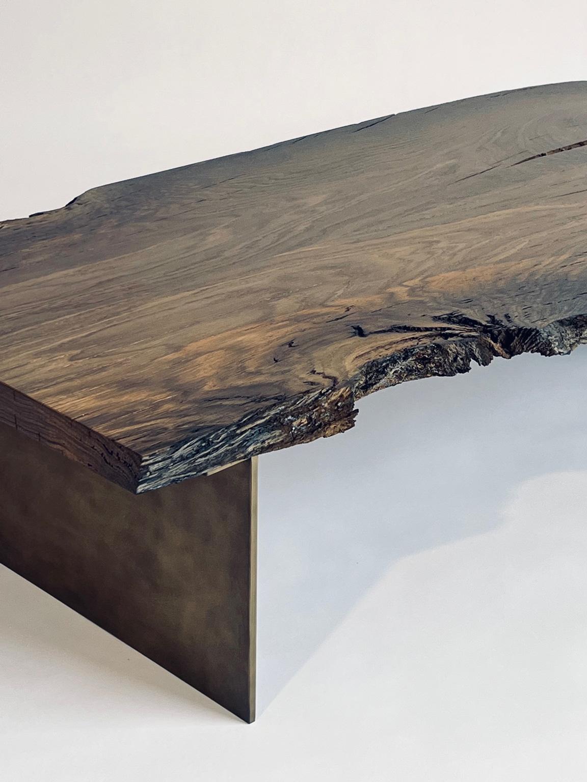 This is a unique coffee table made of Bog Oak, which is approximately 7,000 years old. The wood originates from Romania and has been buried underground for around 7,000 years. It remains intact due to being sealed off from oxygen, preventing decay.
