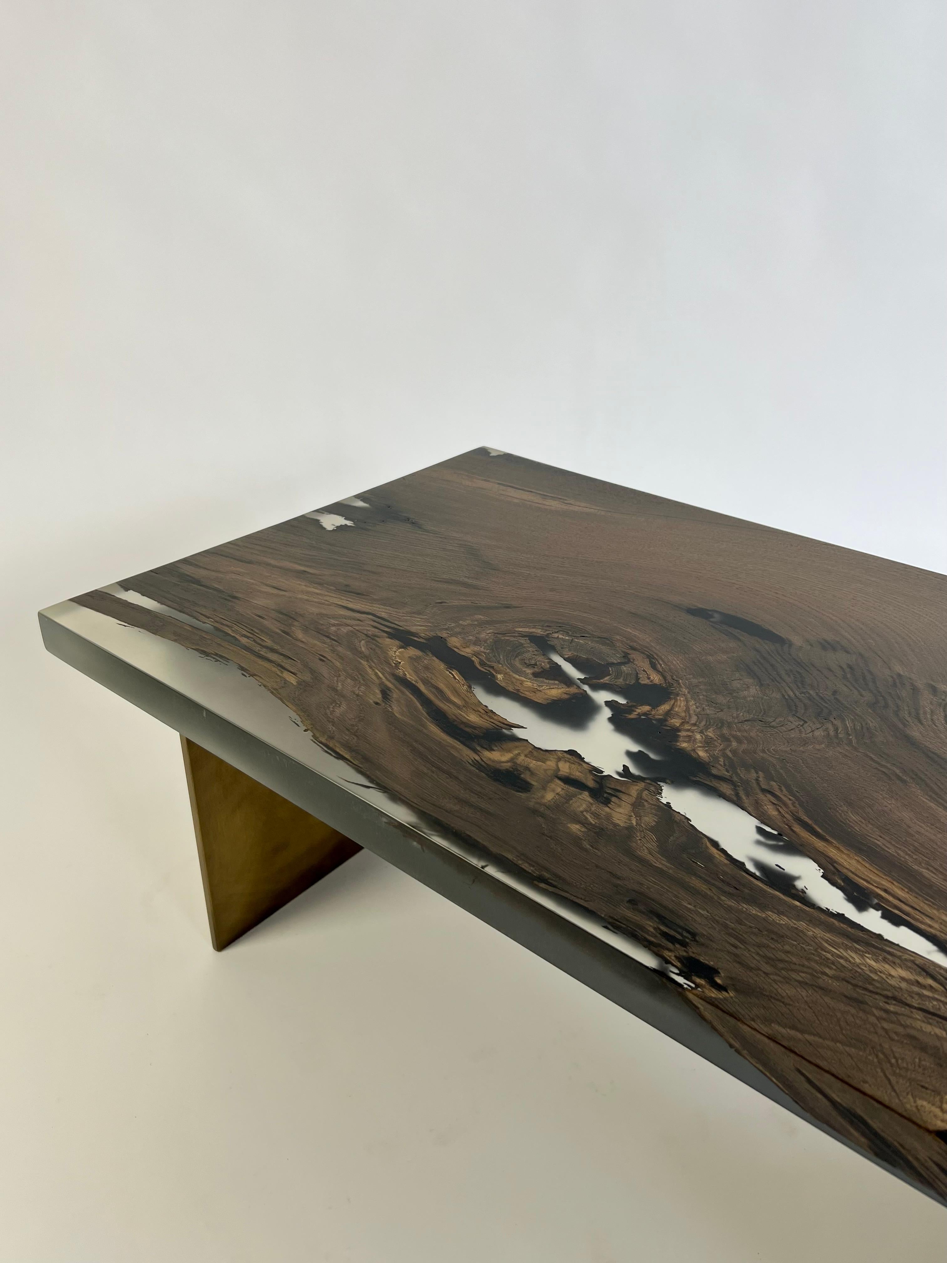 This is a unique coffee table crafted from Bog Oak and epoxy resin. The wood itself is an astounding 7,000 years old, originating from Romania and having remained buried underground for millennia. Its exceptional preservation is owed to its