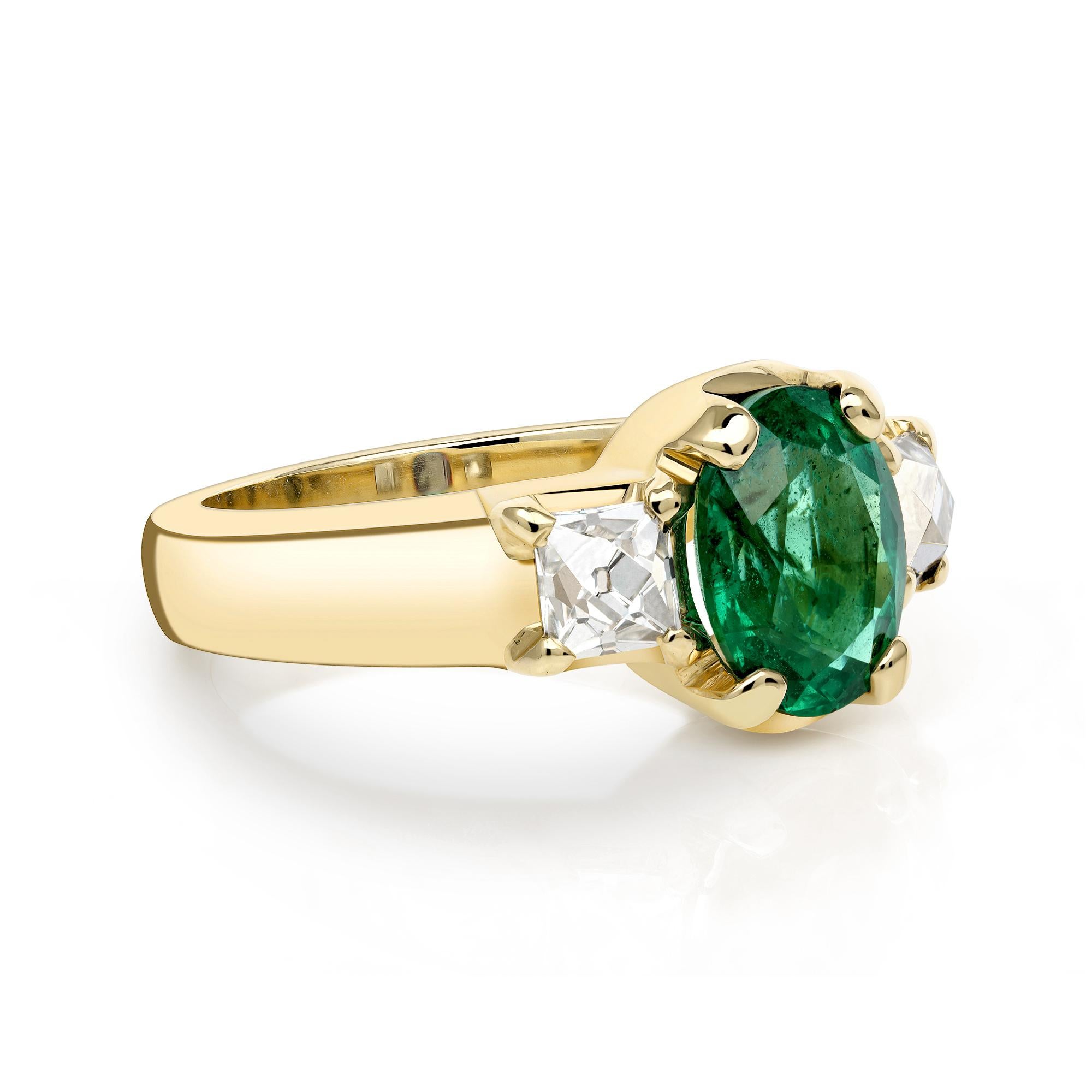 1.73ct GIA certified Zambian Oval cut green emerald flanked by 0.84ctw French cut diamonds prong set in a handcrafted 18K yellow gold mounting.