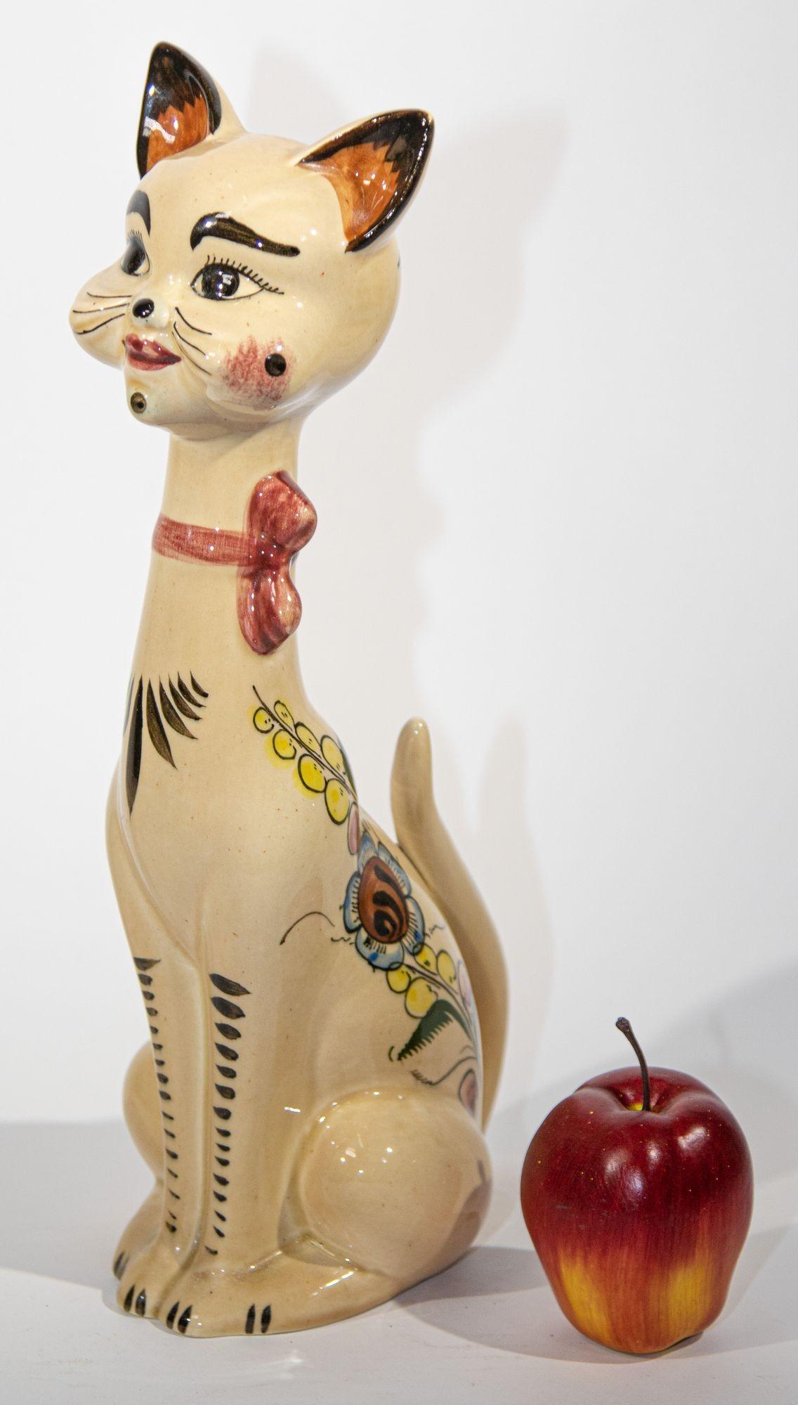 Chat de grande taille en céramique fabriquée à la main, Italie, années 1970.
Figure de chat kitsch en céramique émaillée et peinte à la main avec des fleurs et un oiseau sur son corps.
Cet étonnant et gracieux chat anthropomorphe en céramique à