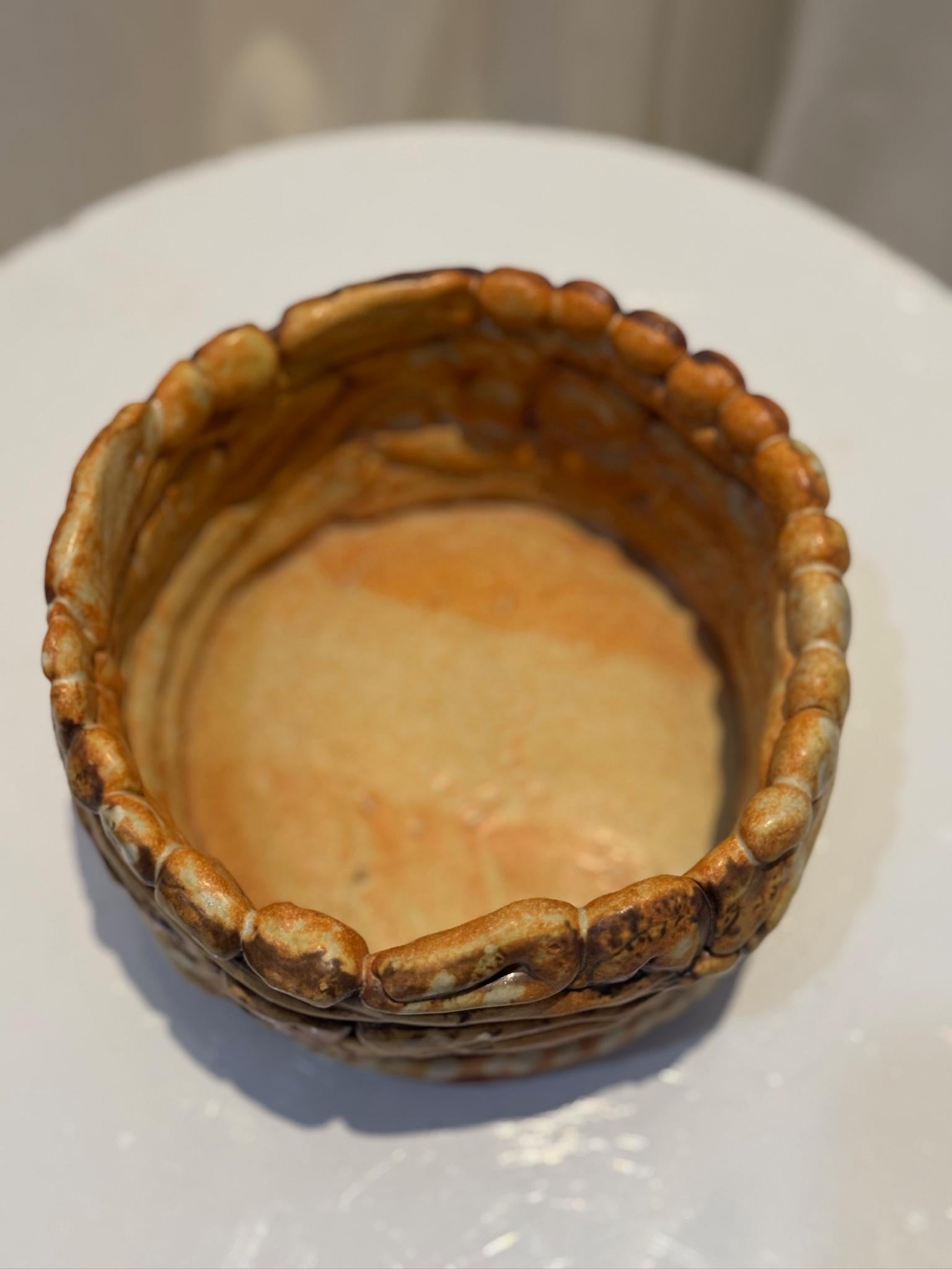 Ce vase en céramique fabriqué à la main présente un motif tourbillonnant et enroulé complexe, incarnant l'art de la poterie organique à forme libre. Chaque bobine est soigneusement sculptée et stratifiée, créant une surface visuellement dynamique et