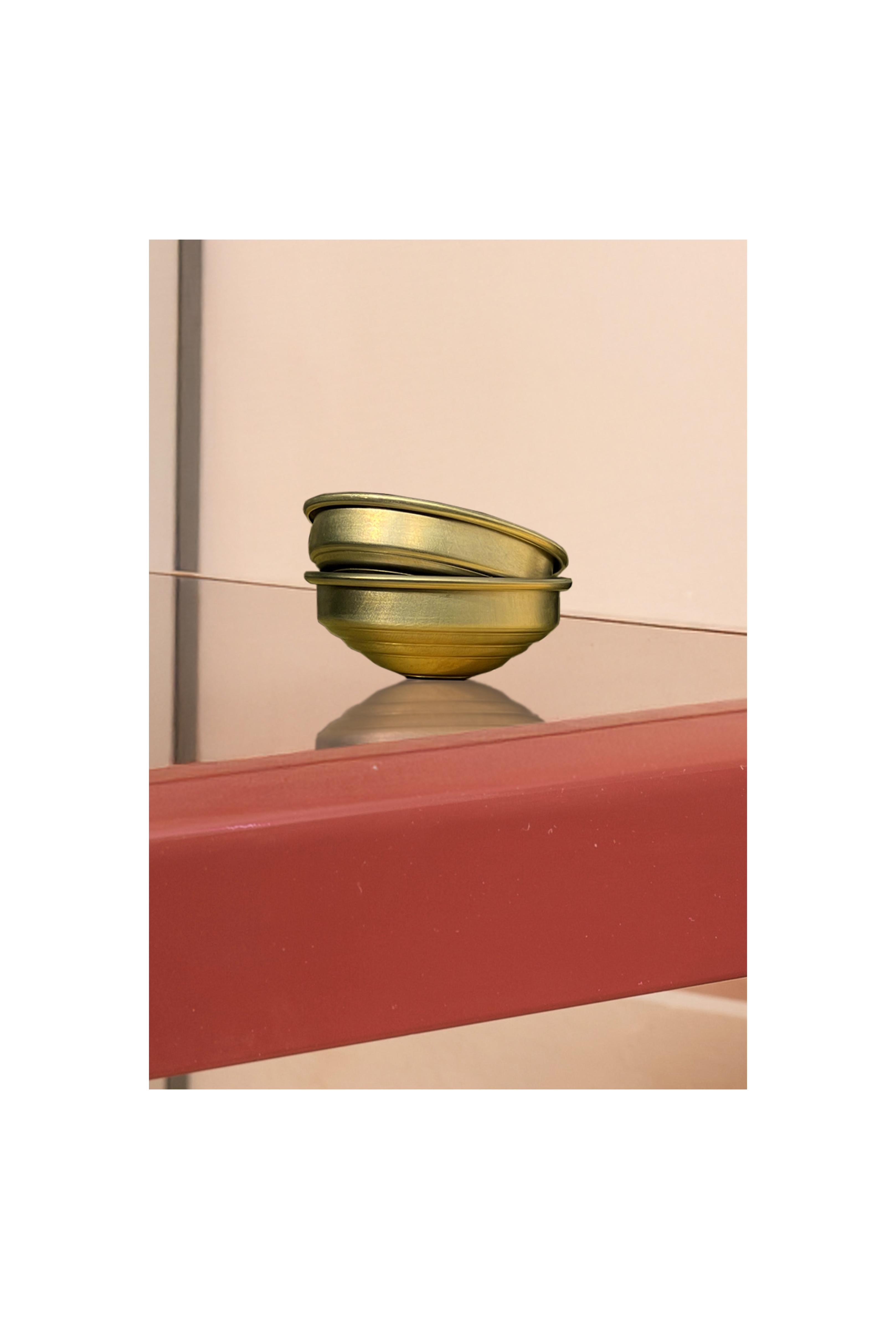 This set of 24 handcrafted satin brass bowls reflects a sophisticated blend of minimalist design and artisanal Italian craftsmanship. With their essential, sculptural form and elegant brushed finish, these small bowls serve as versatile decorative