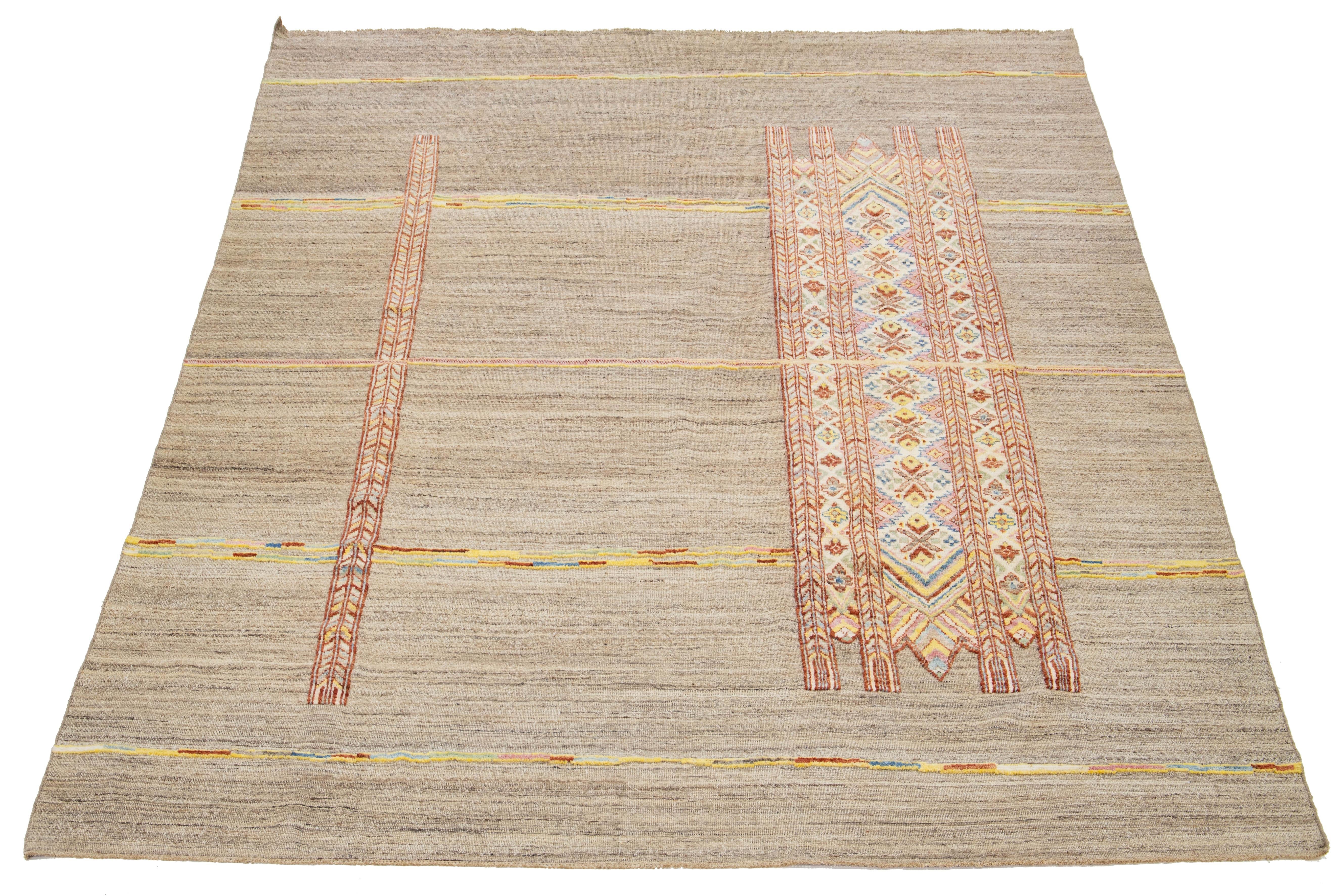 Verschönern Sie Ihren Wohnbereich mit diesem atemberaubenden, handgefertigten Wollteppich im marokkanischen Stil. Dieser Teppich in einem warmen Beigeton verbindet kunstvoll traditionelle Handwerkskunst mit modernen Designelementen. Die