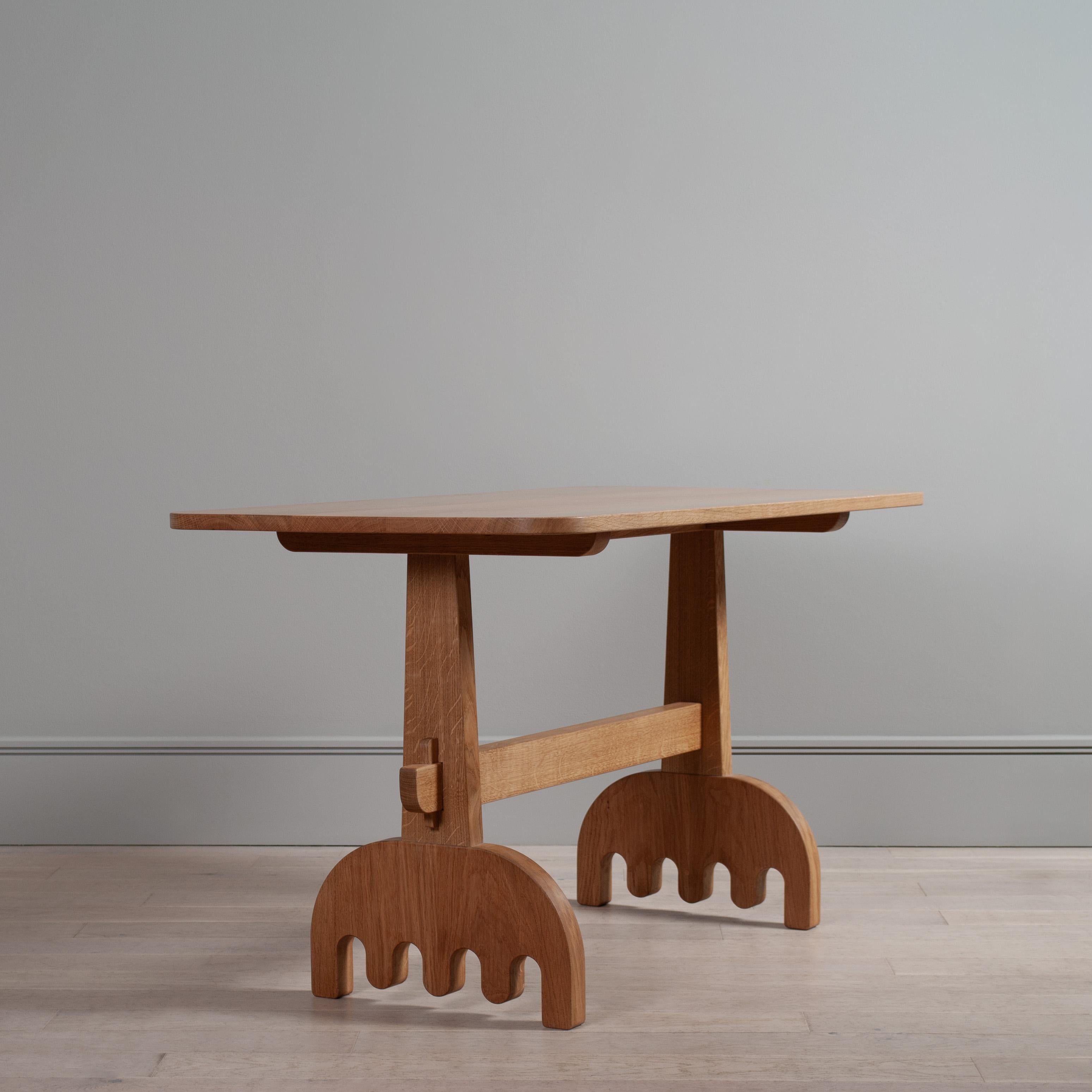 Tavolo multiuso da refettorio contemporaneo in rovere inglese massiccio. Realizzato a mano con incastri a mortasa e tenone sulle gambe e piedi a molla. Si basa su una costruzione tradizionale, ma con un tocco più grosso e giocoso.

Questo tavolo è